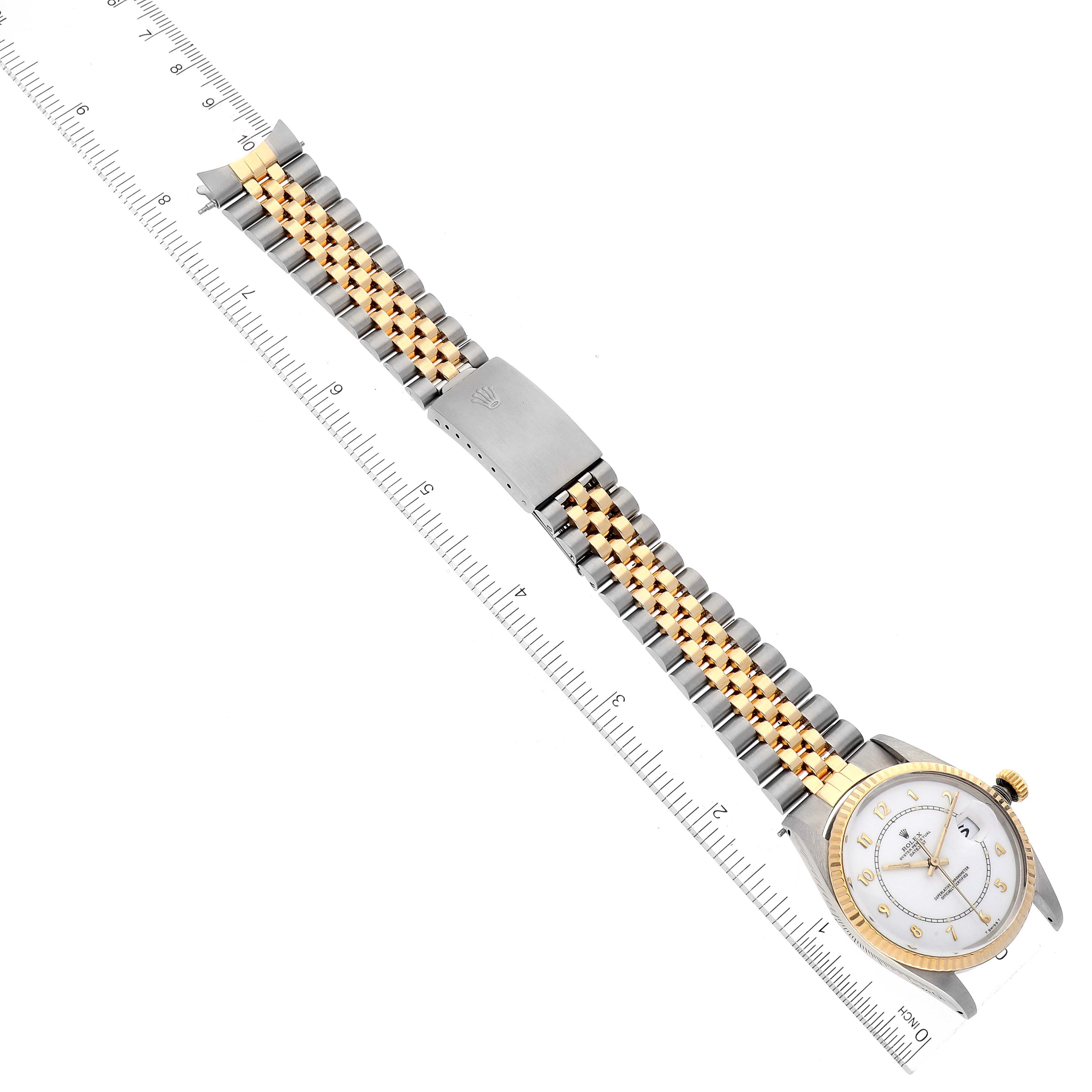 The image shows a Rolex Vintage Collection 16013 Men's Steel and Gold (two tone) White Dial 16013 Men's Steel and Gold (two tone) White Dial watch laid flat with a ruler, highlighting its band and face from a top-down angle.