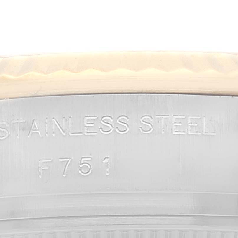 This close-up image shows the edge of a Rolex Datejust 179173 Women's Steel and Gold (two tone) Champagne Dial 179173 Women's Steel and Gold (two tone) Champagne Dial watch case with "STAINLESS STEEL F751" engraved.