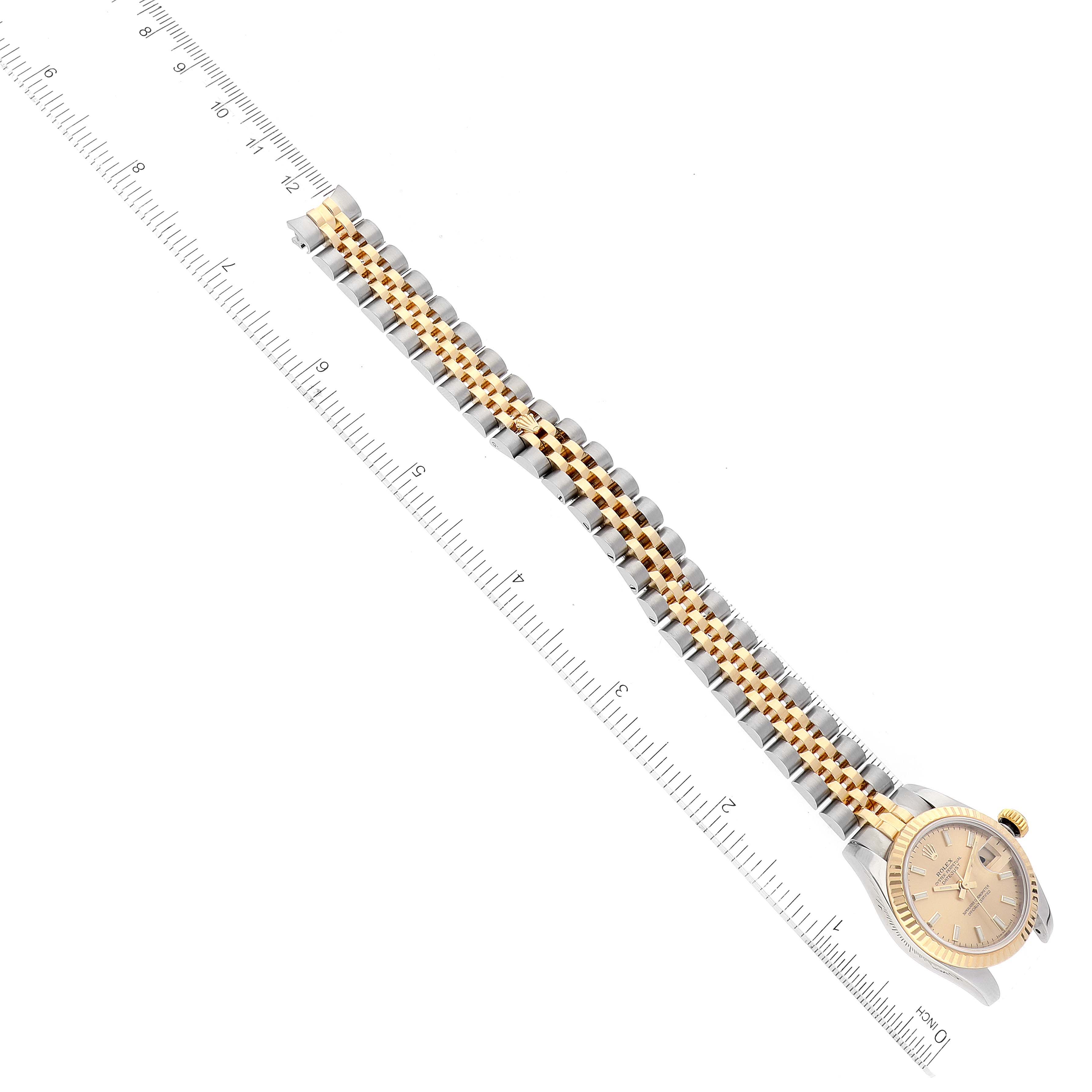 The image shows a Rolex Datejust 179173 Women's Steel and Gold (two tone) Champagne Dial 179173 Women's Steel and Gold (two tone) Champagne Dial watch laid flat with its bracelet extended next to a ruler for measurement.