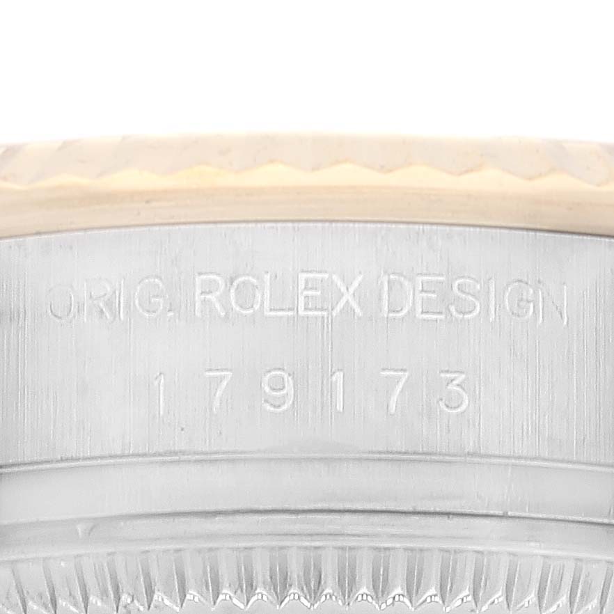 This image shows a close-up of the side of a Rolex Datejust 179173 Women's Steel and Gold (two tone) Champagne Dial 179173 Women's Steel and Gold (two tone) Champagne Dial watch case, revealing the serial number and "ORIG. ROLEX DESIGN" engraving.
