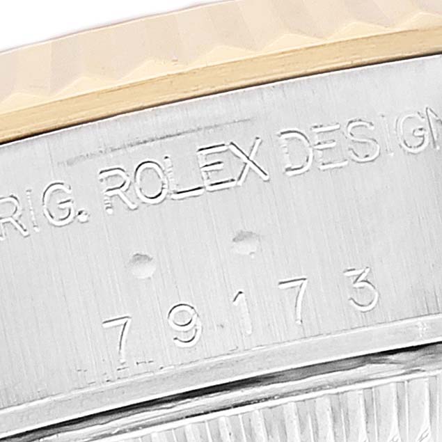 This close-up image of a Rolex Datejust 79173 Women's Steel and Gold (two tone) Beige Dial 79173 Women's Steel and Gold (two tone) Beige Dial watch shows the model number and the engraving on the bezel and case.