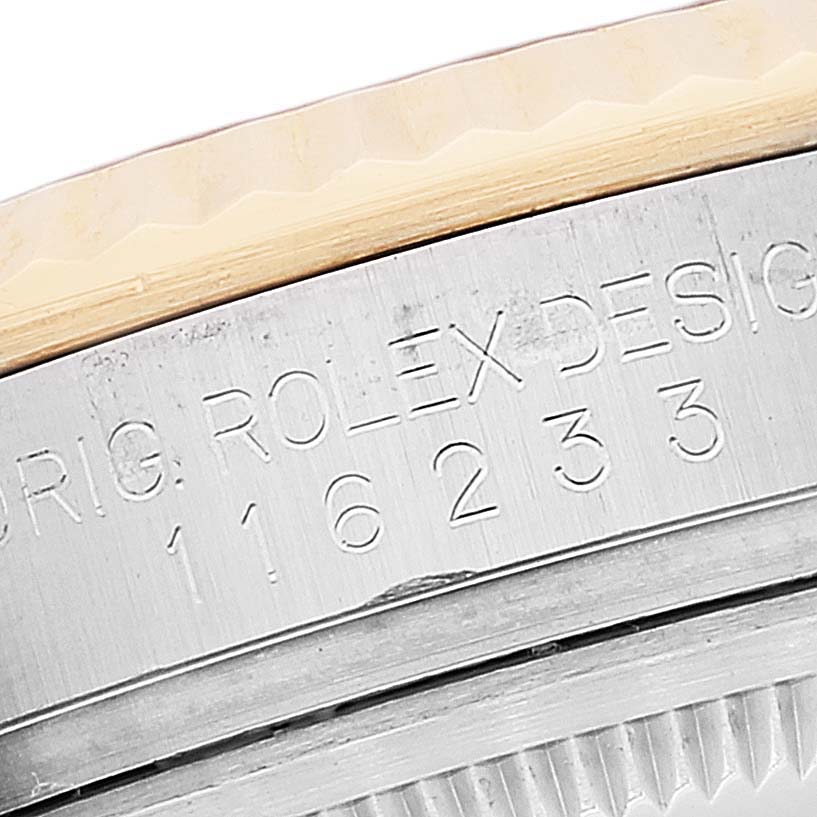 The image shows a close-up of the engraved serial number and the edge of the bezel on a Rolex Datejust 116233 Men's Steel and Gold (two tone) Silver Dial 116233 Men's Steel and Gold (two tone) Silver Dial watch.