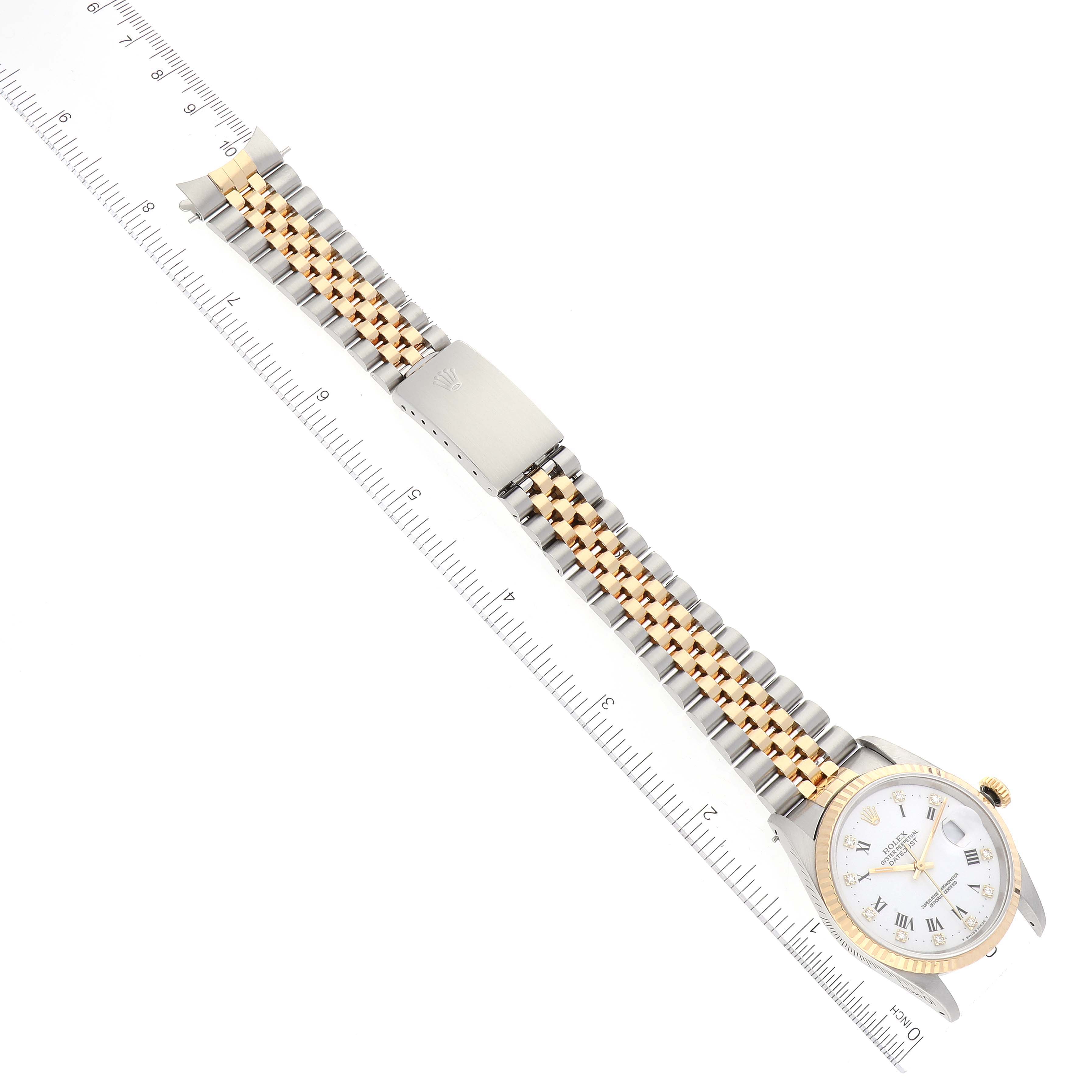 The image shows a Rolex Datejust 16233 Men's Steel and Gold (two tone) White Dial 16233 Men's Steel and Gold (two tone) White Dial watch lying flat with both the bracelet and face visible, alongside a measuring ruler.