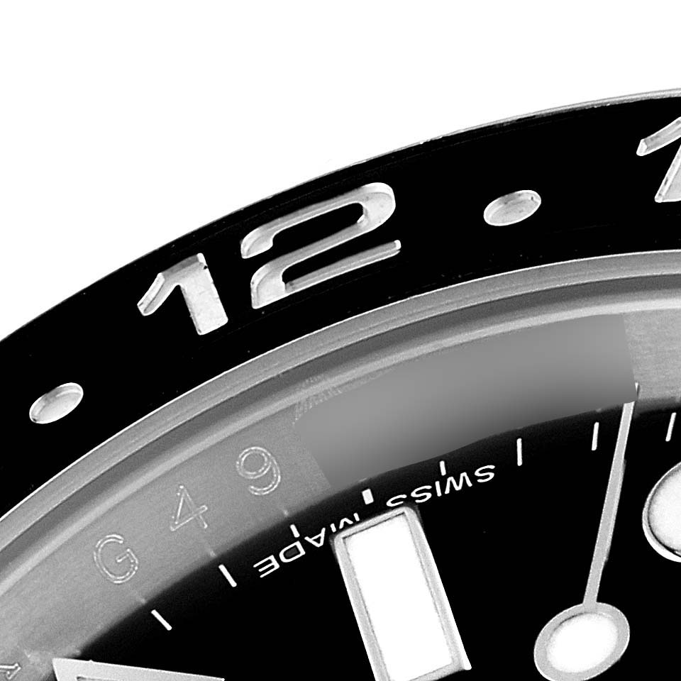 This image shows a close-up of the bezel and partial dial of a Rolex GMT-Master 116710 Men
s Stainless Steel Black Dial 116710 Men
s Stainless Steel Black Dial watch, including the "12" marker and "Swiss Made" text.