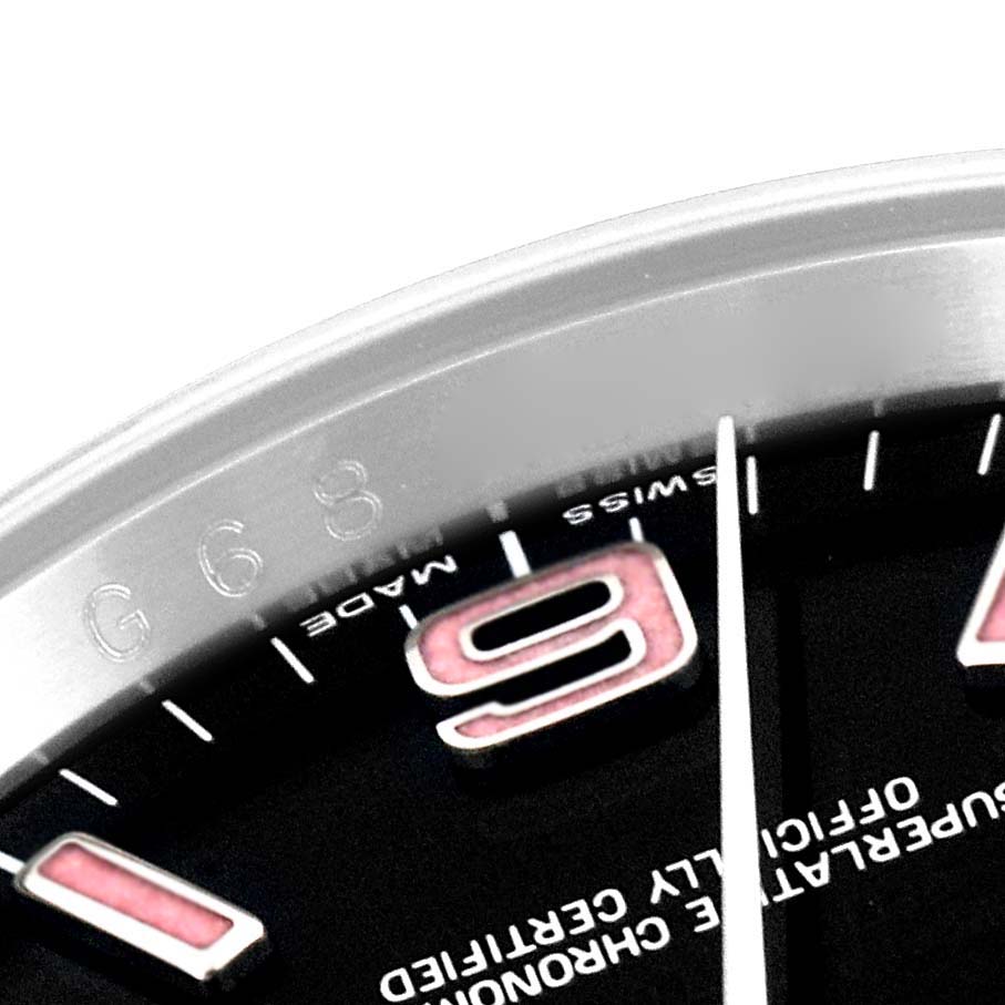 This close-up image of a Rolex Oyster Perpetual 116000 Men
s Stainless Steel Black Dial 116000 Men
s Stainless Steel Black Dial watch shows part of the bezel, 9 o
clock marker, and surrounding text.