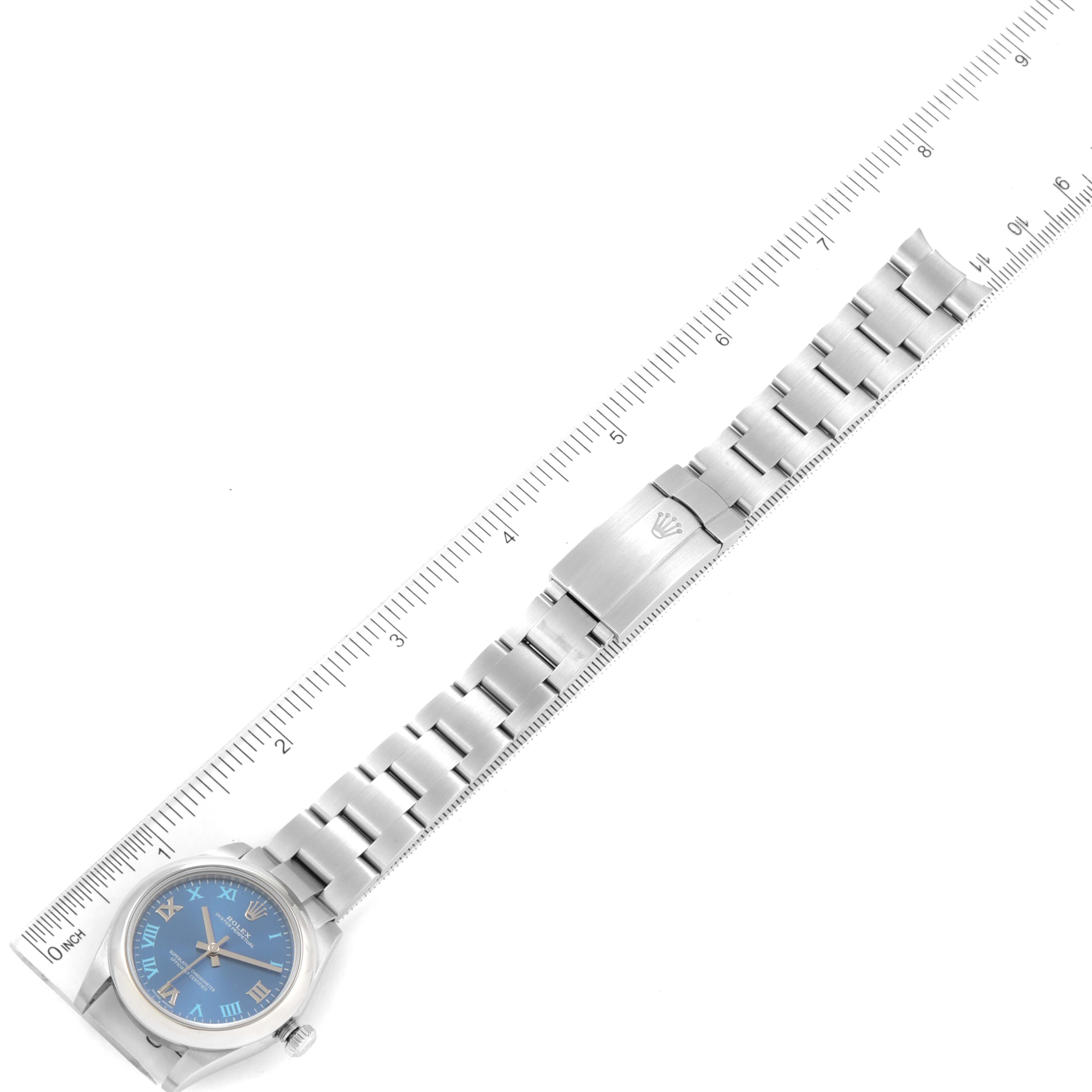 The image shows a Rolex Mid-Size 177200 Women
s Stainless Steel Blue Dial 177200 Women
s Stainless Steel Blue Dial model watch laid flat with its bracelet fully extended next to a ruler for measurement.