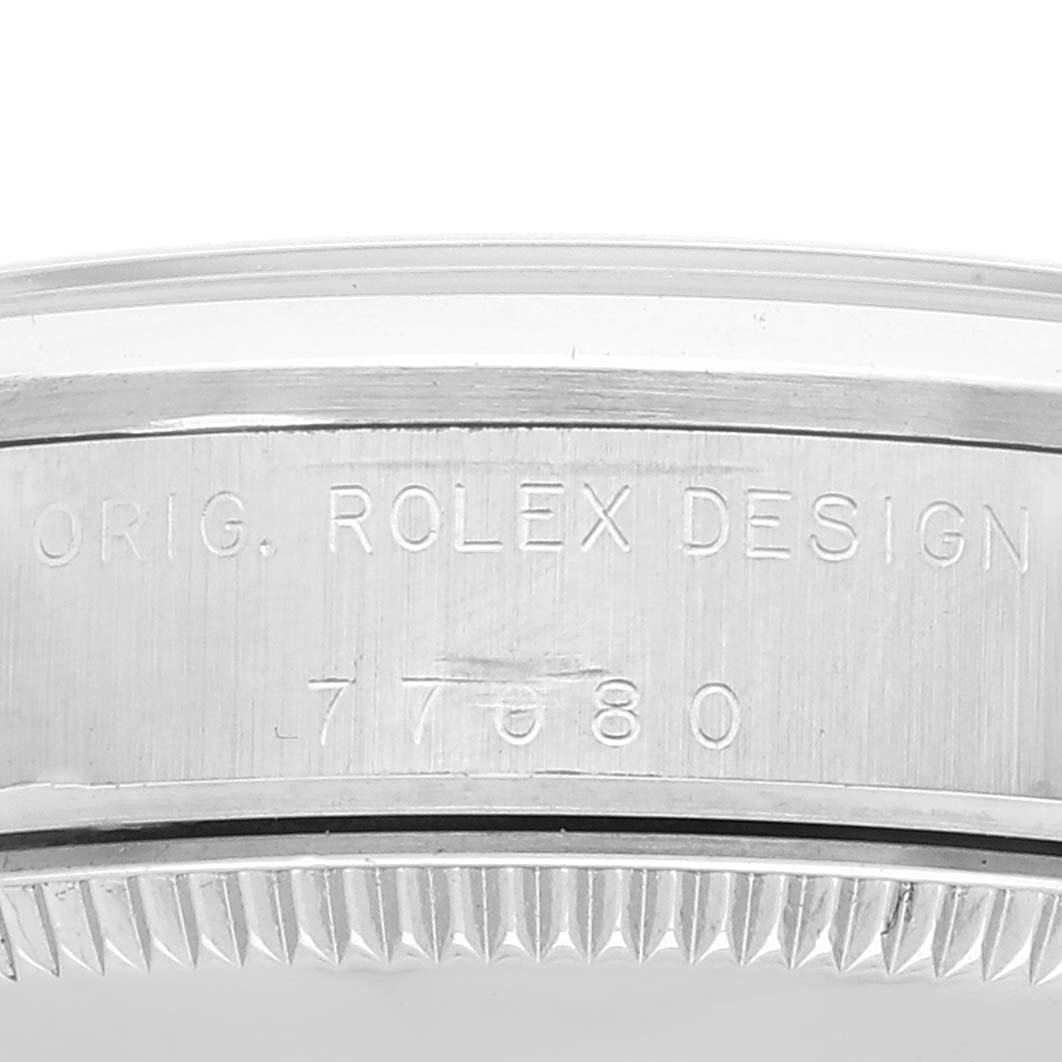 This is a close-up shot of the side of the Rolex Mid-Size 77080 Women
s Stainless Steel Blue Dial 77080 Women
s Stainless Steel Blue Dial model showing the engraving with the design number 7780.