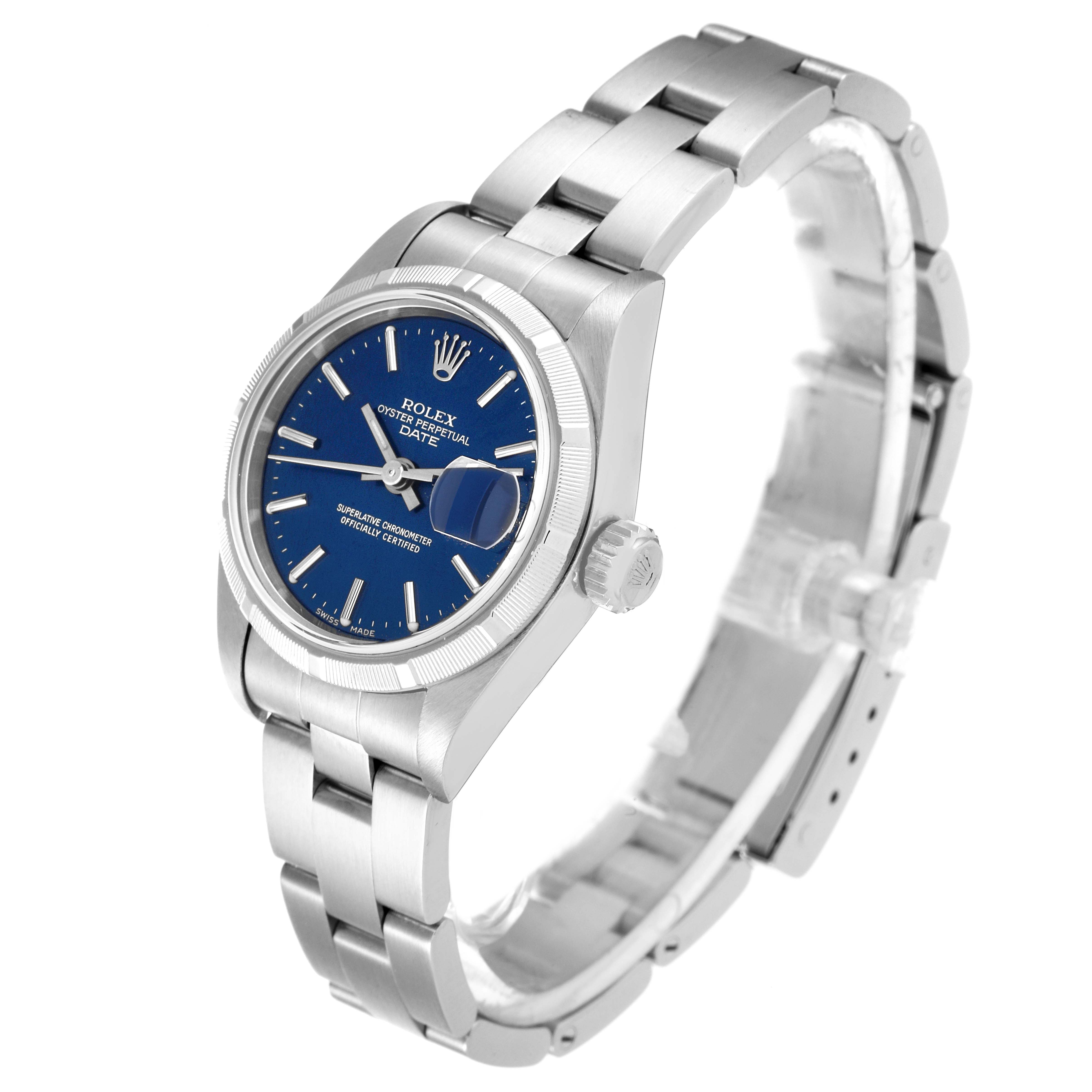 The image shows an angled view of the Rolex Oyster Perpetual Date watch, highlighting its blue dial, bezel, crown, and bracelet.