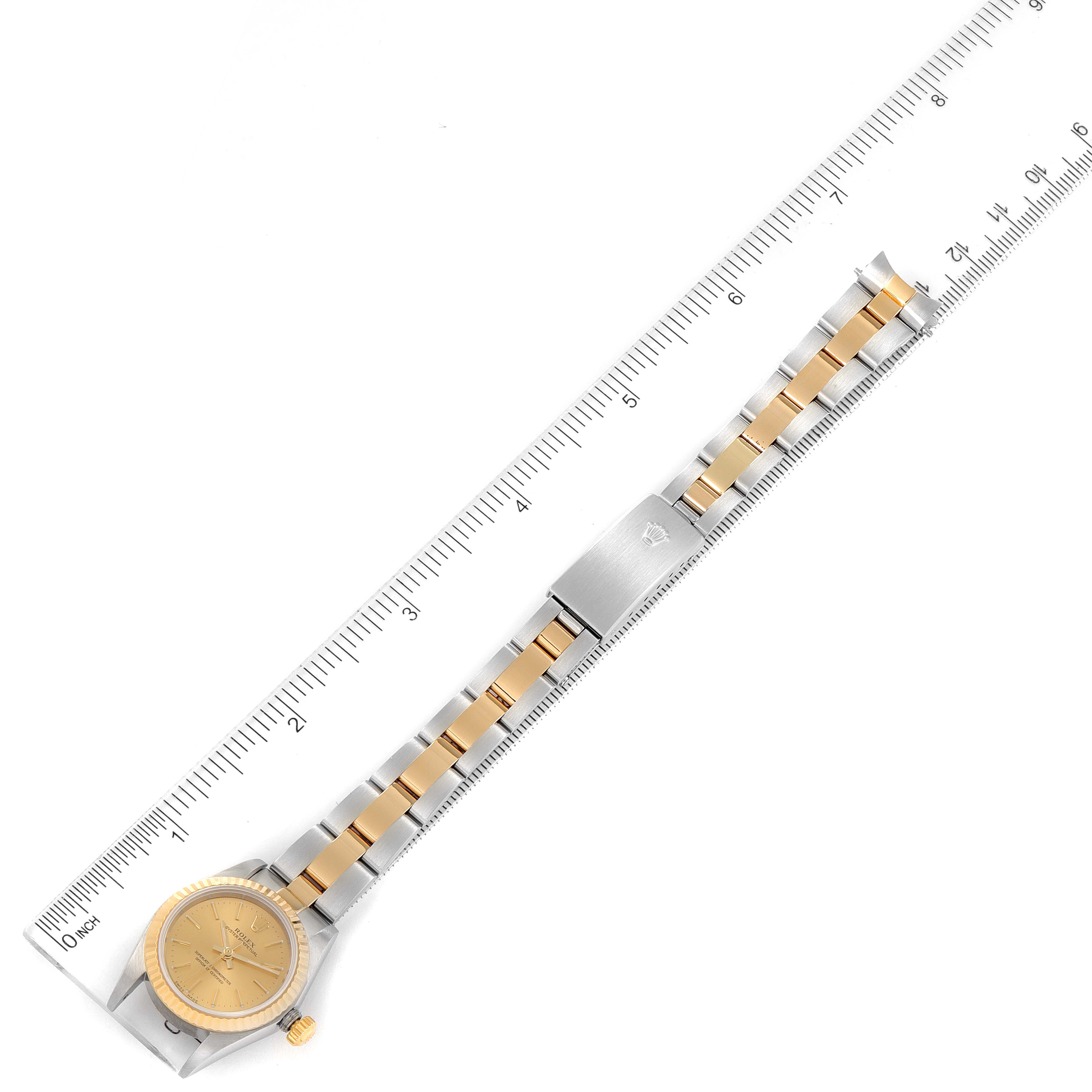 The Rolex Oyster Perpetual 76193 Women's Steel and Gold (two tone) Champagne Dial 76193 Women's Steel and Gold (two tone) Champagne Dial watch is shown flat, with the bracelet fully extended beside a ruler for scale.