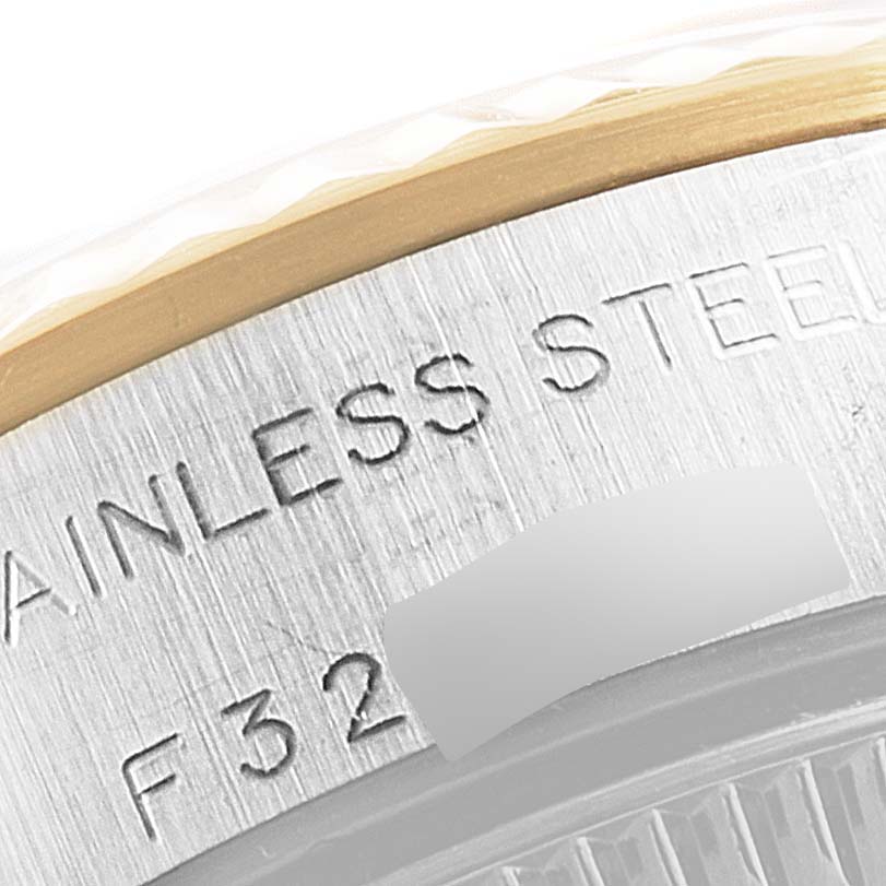 The image shows a close-up of the side of a Rolex Oyster Perpetual 76193 Women's Steel and Gold (two tone) Champagne Dial 76193 Women's Steel and Gold (two tone) Champagne Dial watch with "STAINLESS STEEL" engraving and a partial serial number.
