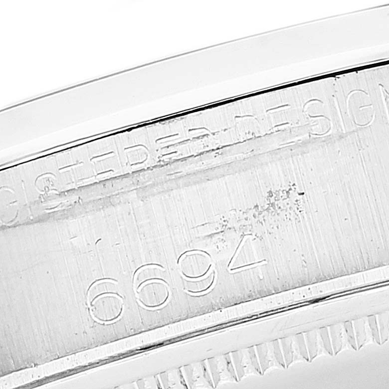 This image shows an engraved part of the Rolex Vintage Collection 6694 Men's Stainless Steel Black Dial 6694 Men's Stainless Steel Black Dial model, focusing on the case's serial number and some text details.