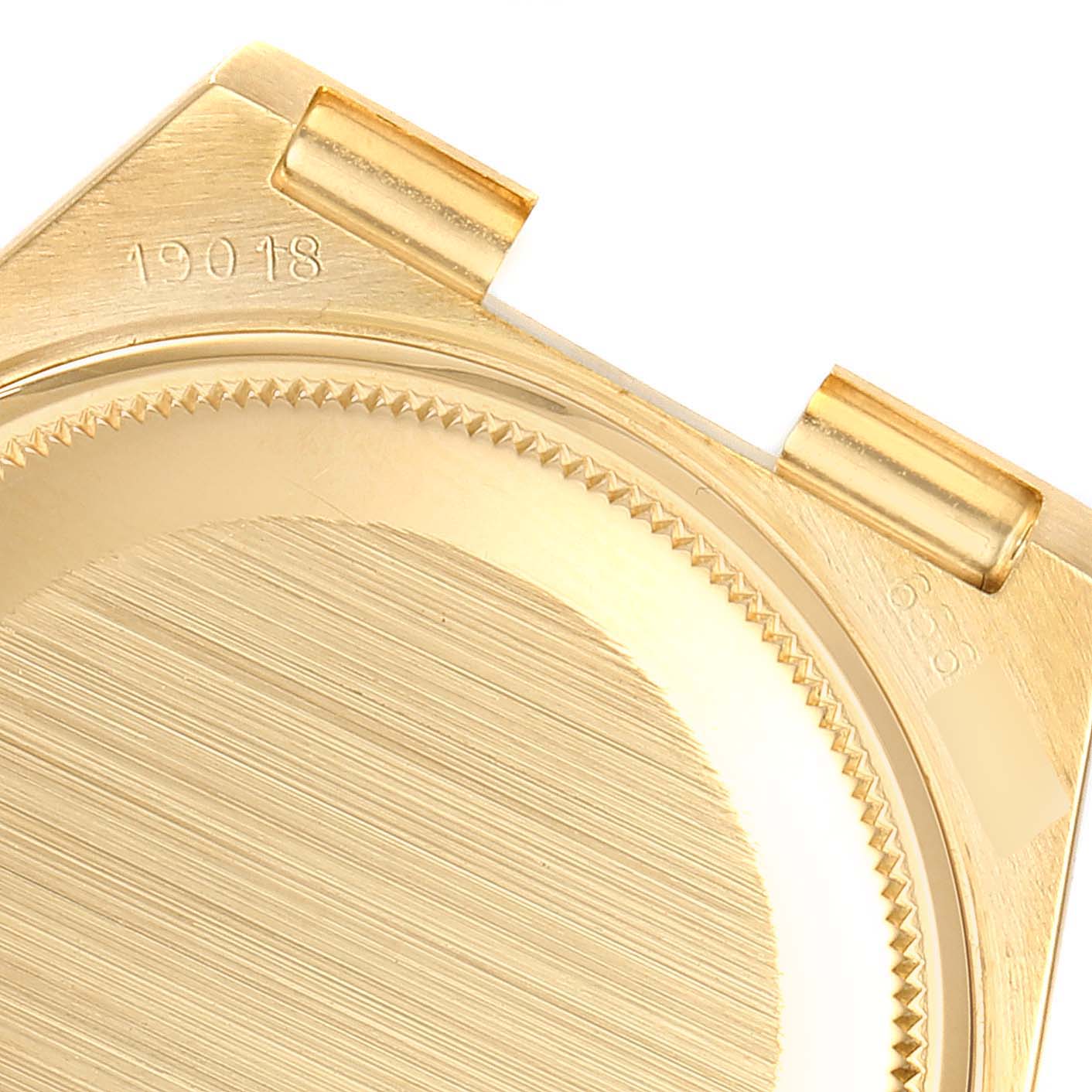 The image shows the back case and lugs of a President model by Rolex, focusing on its metallic texture and engravings.