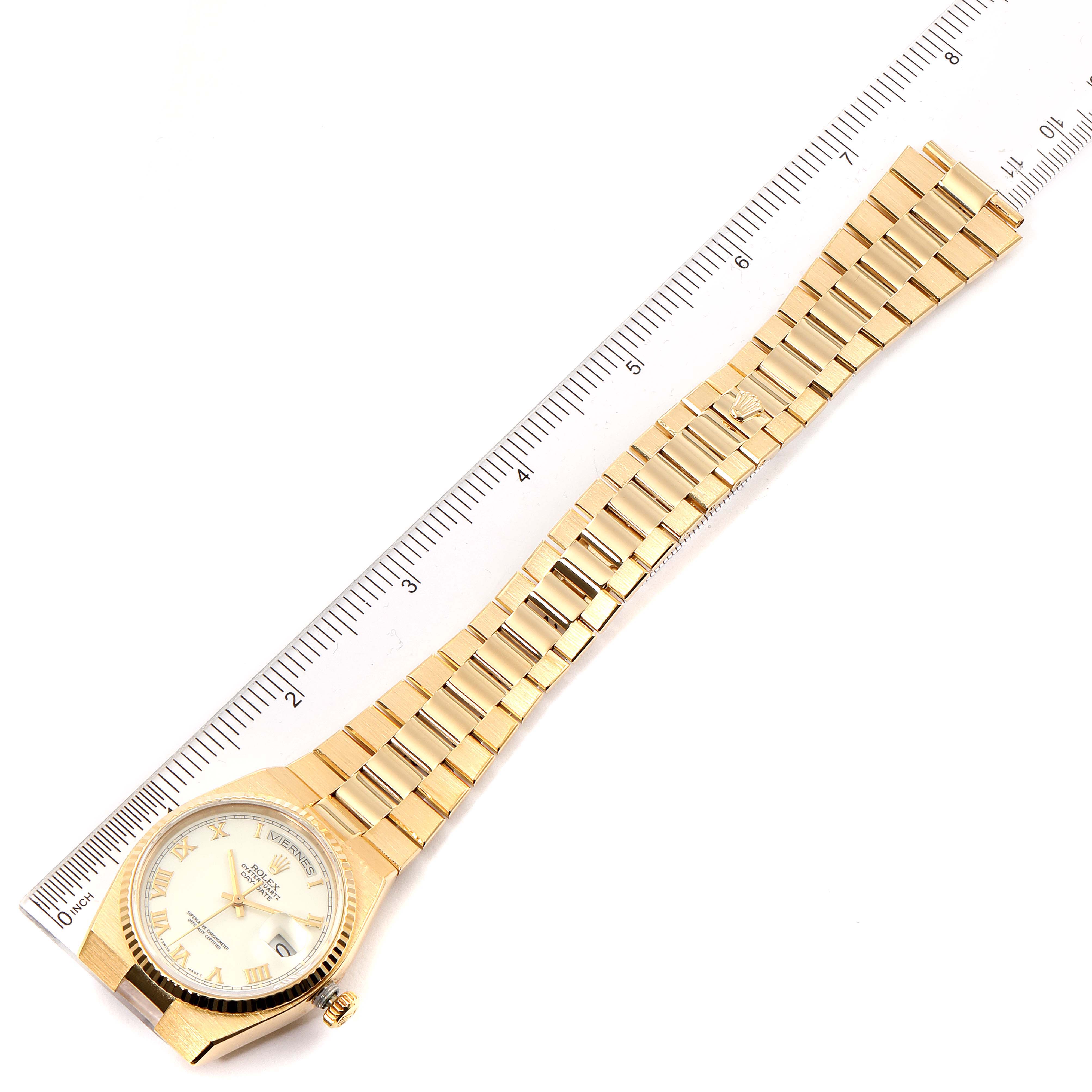 This image shows a Rolex President 19018 Men's Yellow Gold White Dial 19018 Men's Yellow Gold White Dial model watch from a top-down angle, displaying its full bracelet and face next to a ruler.