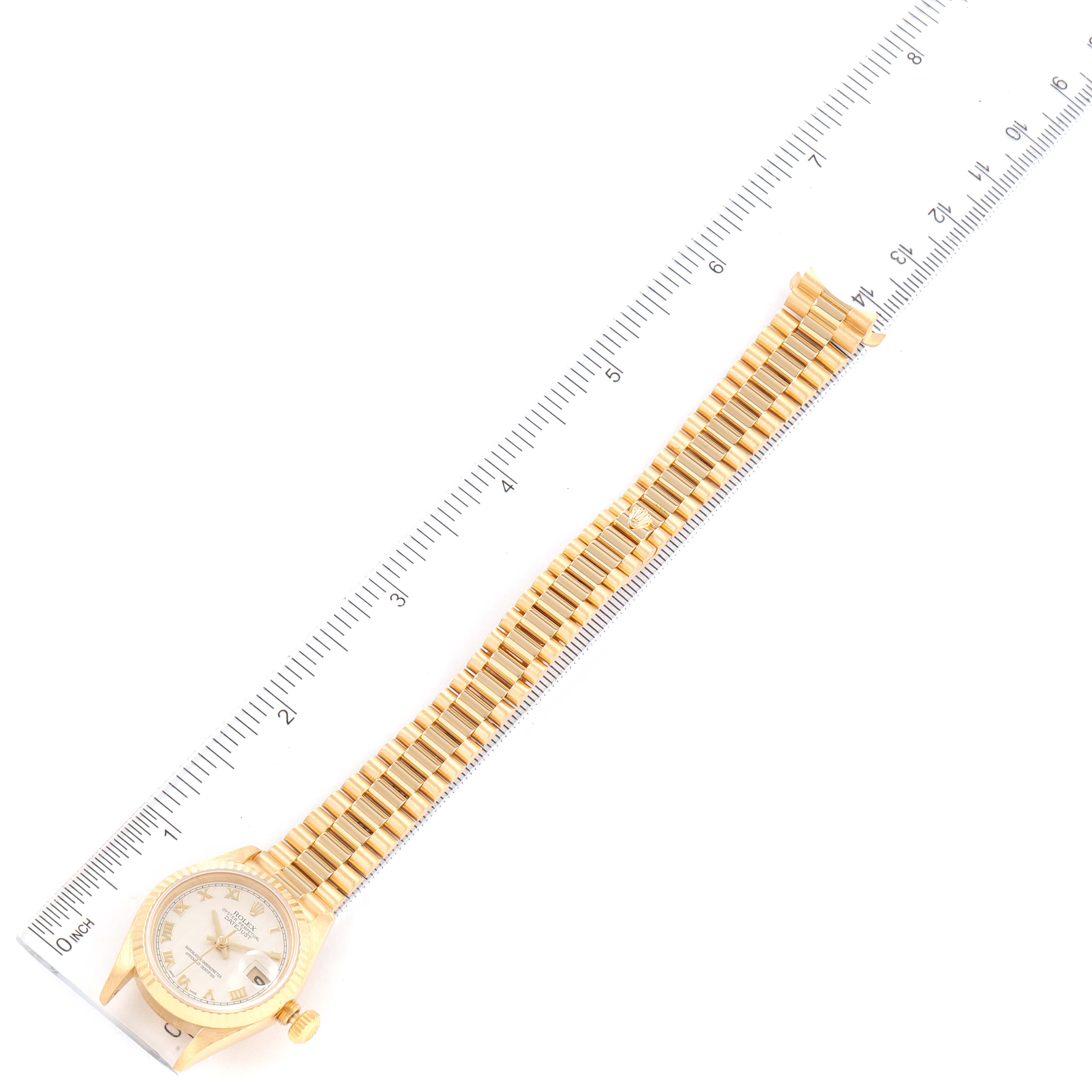 A Rolex President 69178 Women's Yellow Gold Beige Dial 69178 Women's Yellow Gold Beige Dial model watch is shown laid flat with the strap extended and aligned next to a ruler for measurement.