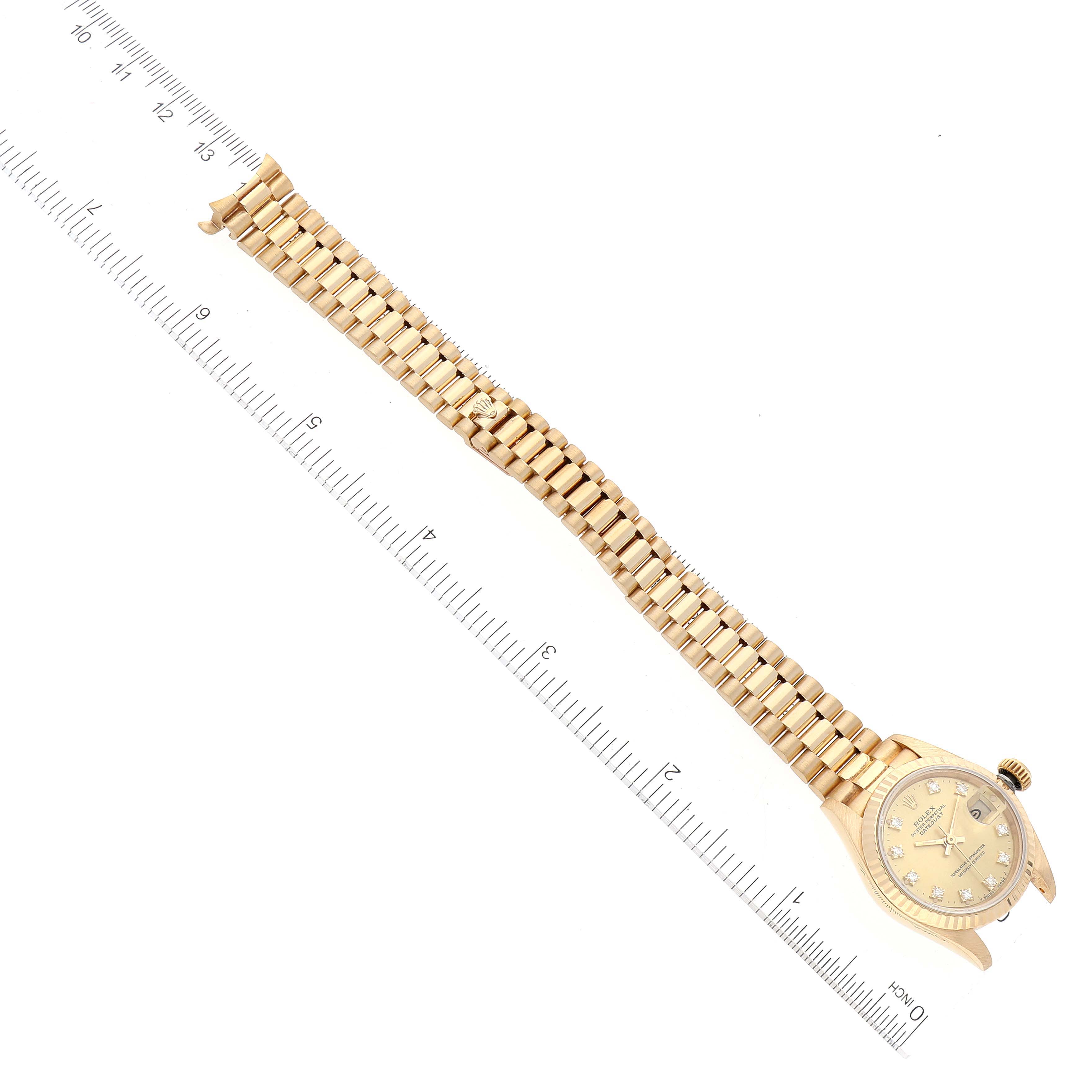 The Rolex President 69178 Women
s Yellow Gold Champagne Dial 69178 Women
s Yellow Gold Champagne Dial model watch is shown from an overhead angle, displaying its face, bracelet, and connected ruler for measurement.