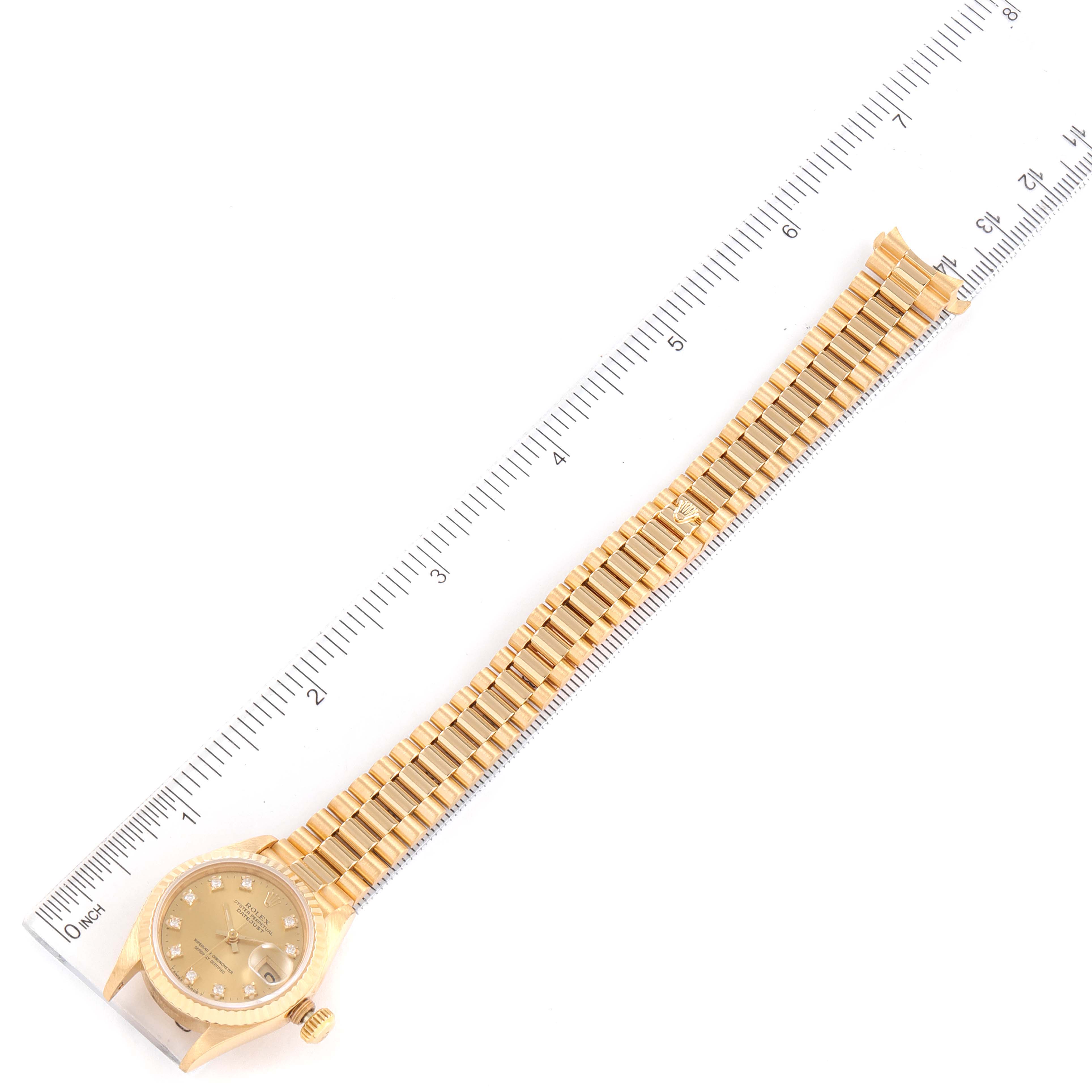 The image shows a Rolex President 69178 Women
s Yellow Gold Champagne Dial 69178 Women
s Yellow Gold Champagne Dial model watch laid flat with a ruler measuring its length.