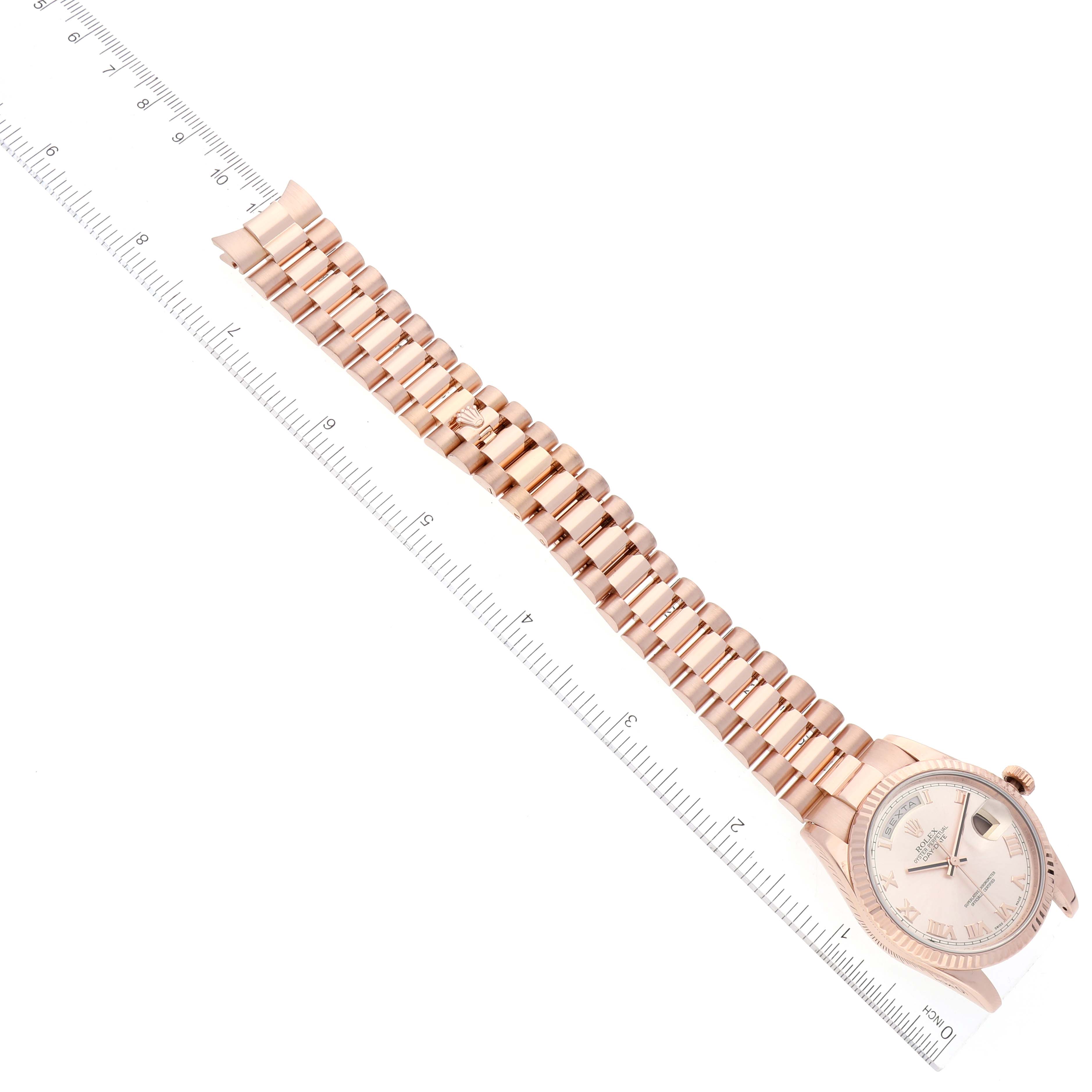 The image shows a Rolex President 118235 Men's Rose Gold Pink Dial 118235 Men's Rose Gold Pink Dial model watch, laid flat with its face and full bracelet visible alongside a measurement ruler.