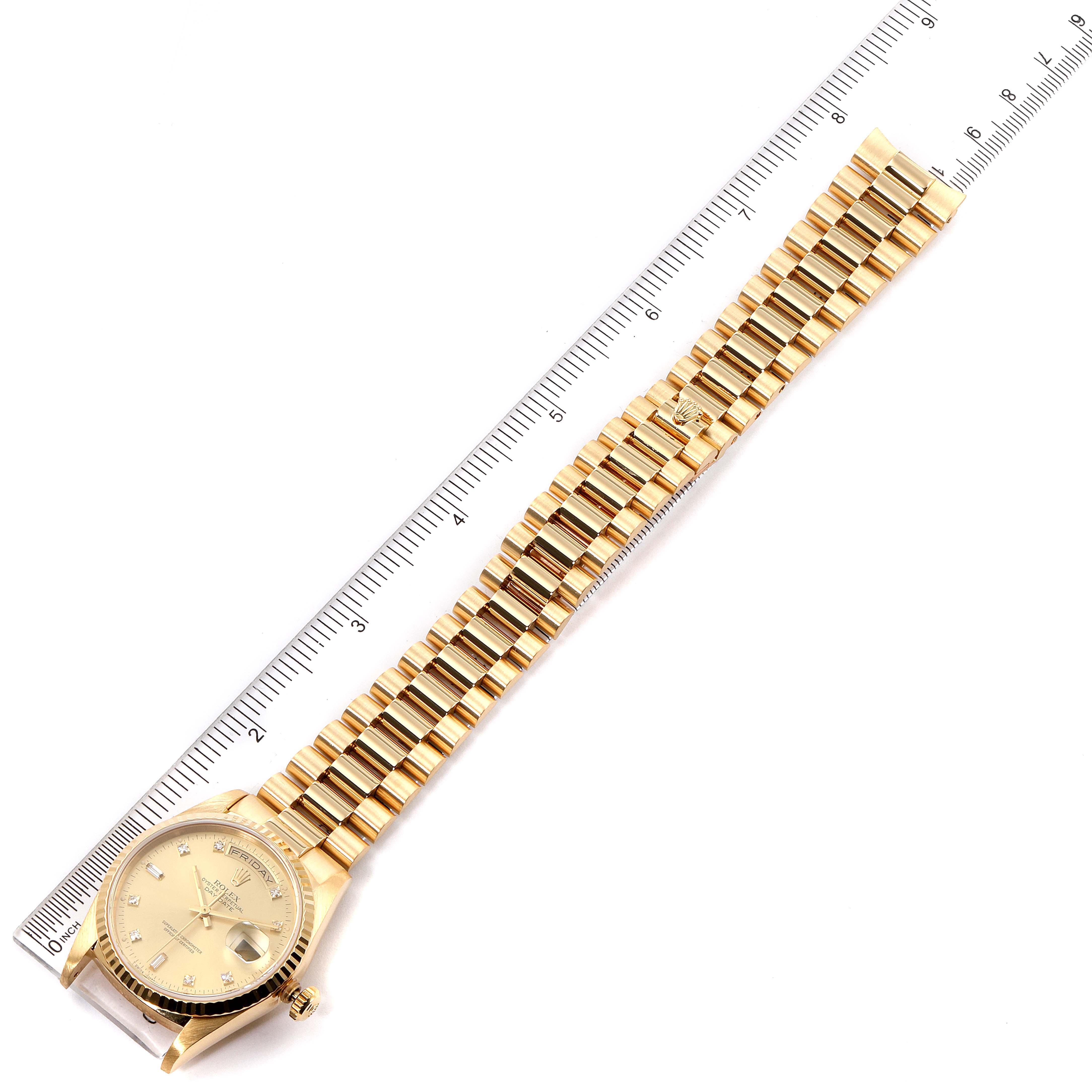 The Rolex President 18238 Men
s Yellow Gold Champagne Dial 18238 Men
s Yellow Gold Champagne Dial watch is shown flat with its face, band, and clasp visible, placed alongside a ruler.