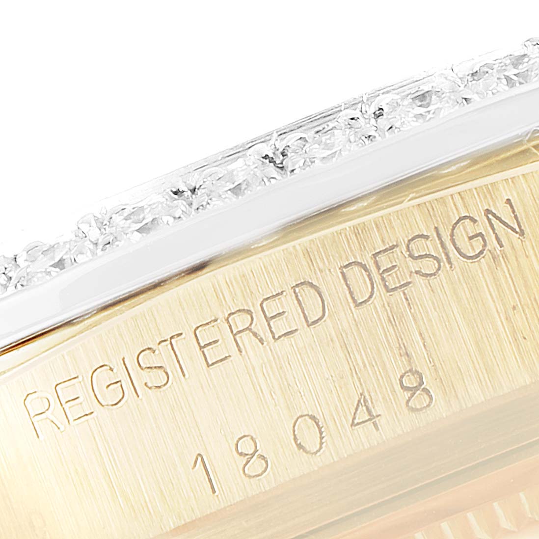 This close-up image shows the side engraving and part of the bezel on the Rolex President 18048 Men
s Yellow Gold Black Dial 18048 Men
s Yellow Gold Black Dial model watch.