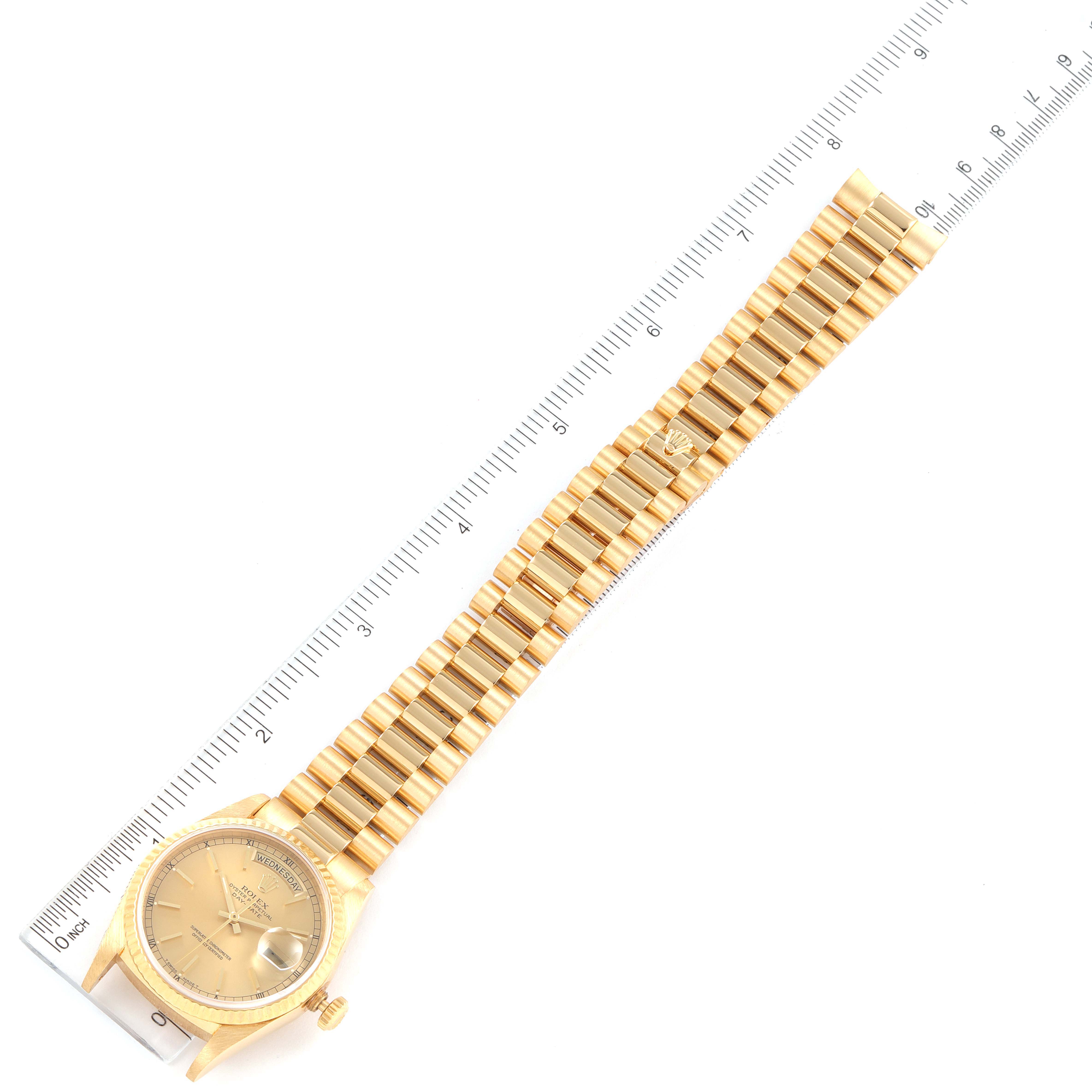 The image shows a top-down view of the entire Rolex President 18238 Men
s Yellow Gold Champagne Dial 18238 Men
s Yellow Gold Champagne Dial model watch, including the face, bracelet, and clasp, beside a ruler.