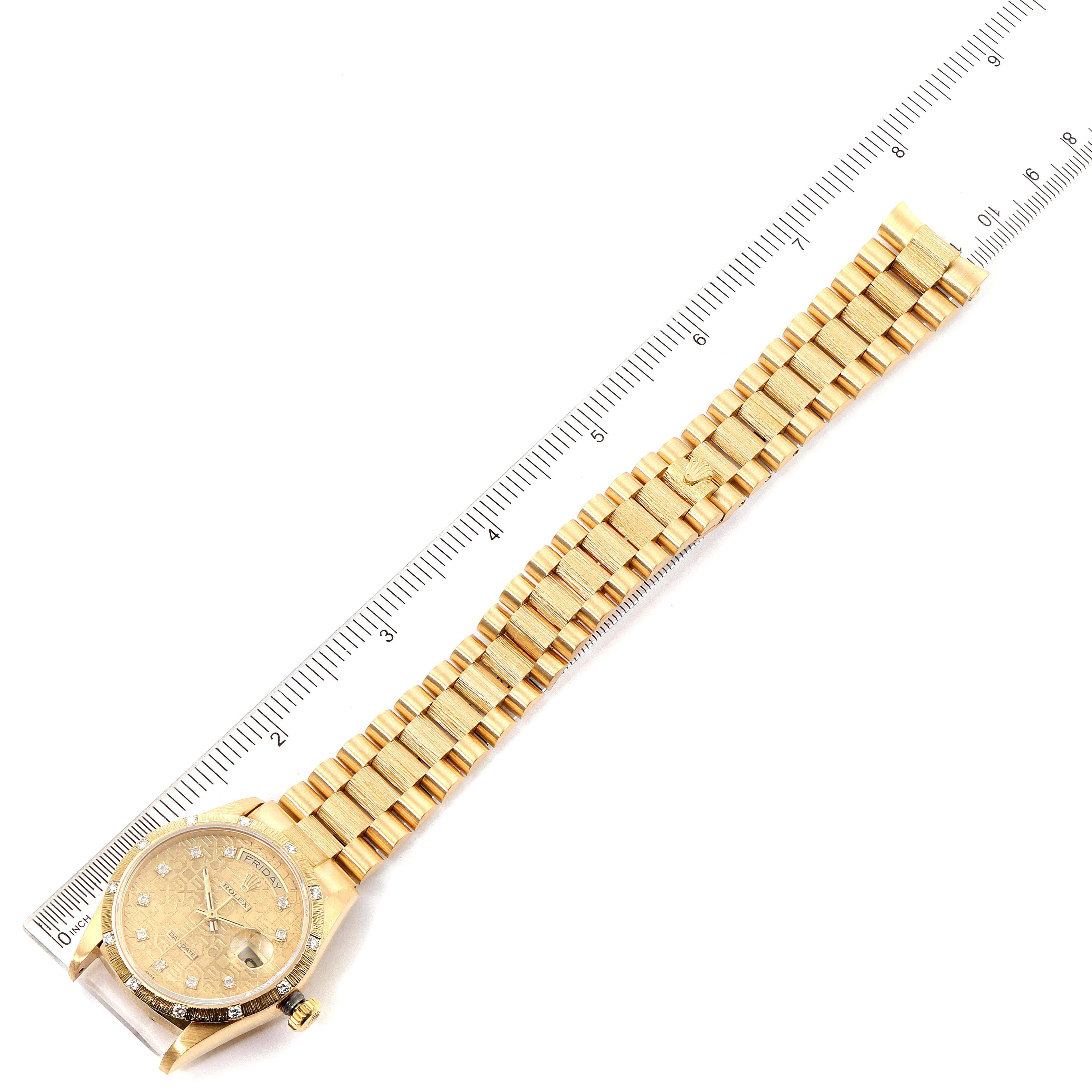 The image shows a top-down view of a Rolex President 18108 Men
s Yellow Gold Champagne Dial 18108 Men
s Yellow Gold Champagne Dial model watch, displaying its golden bracelet against a measuring ruler.