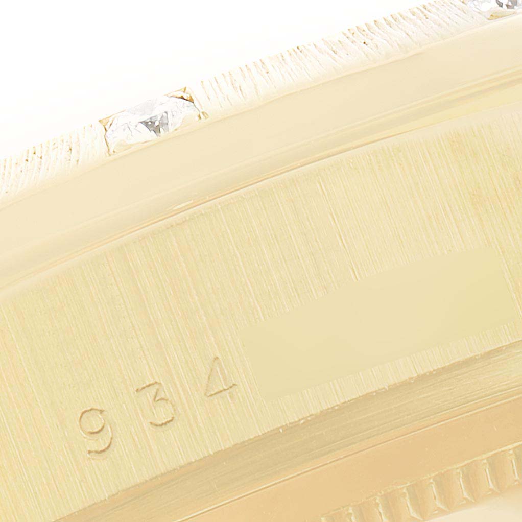 The image shows a close-up of the Rolex President 18108 Men
s Yellow Gold Champagne Dial 18108 Men
s Yellow Gold Champagne Dial model
s case side, featuring part of the bezel with diamonds and engraved markings.