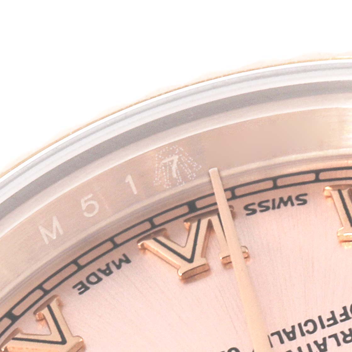 This close-up image of the Rolex President 179175 Women's Rose Gold Pink Dial 179175 Women's Rose Gold Pink Dial model watch shows part of the dial, including Roman numerals, a minute marker, and the words "SWISS MADE."