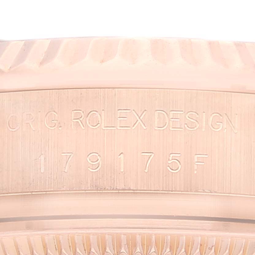 This image shows a close-up of the Rolex President 179175 Women's Rose Gold Pink Dial 179175 Women's Rose Gold Pink Dial model's serial number and engraved text on the watch case.