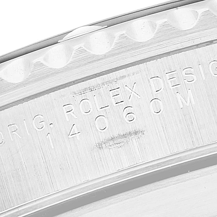 This image shows a close-up of the engraved serial details on the side case of a Rolex Submariner 14060 Men
s Stainless Steel Black Dial 14060 Men
s Stainless Steel Black Dial watch.