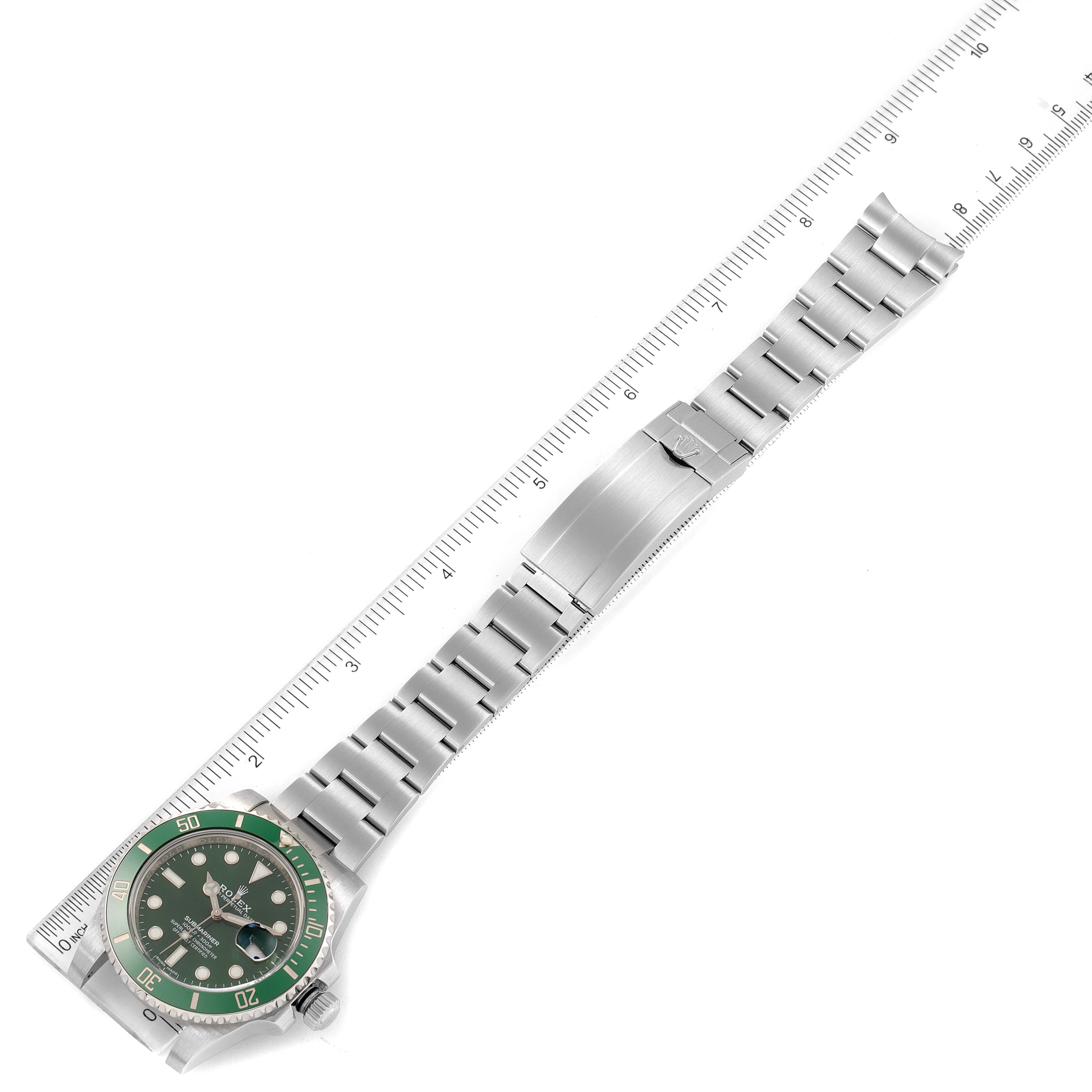 The Rolex Submariner 116610LV Men
s Stainless Steel Green Dial 116610LV Men
s Stainless Steel Green Dial watch is shown from a top-down angle, including the face, bezel, and full bracelet against a ruler for scale.