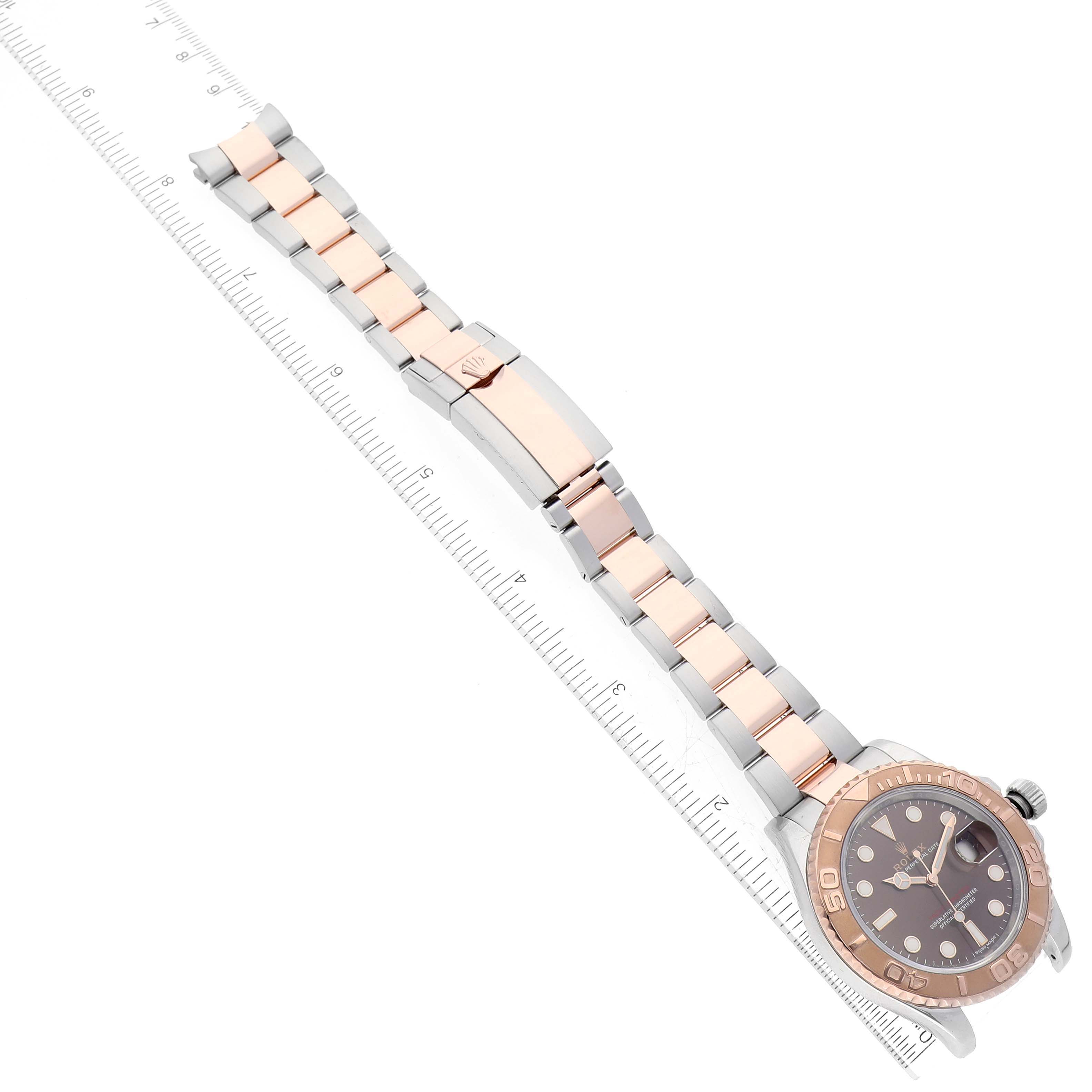 The image shows a Rolex Yacht-Master 116621 Men's Steel and Gold (two tone) Brown Dial 116621 Men's Steel and Gold (two tone) Brown Dial watch from a top-down angle, displaying the face, bezel, and the entirety of the bracelet alongside a ruler.