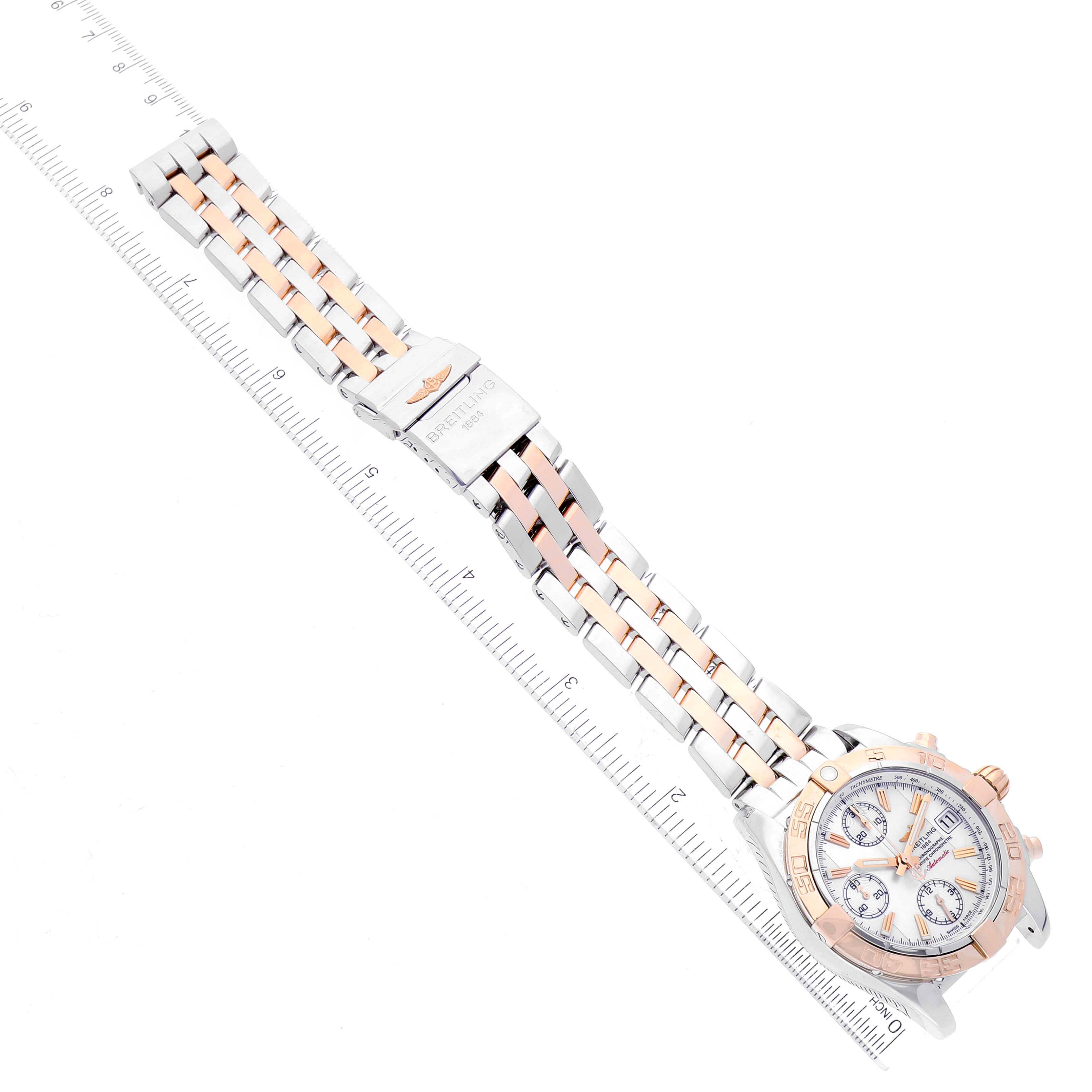 The Breitling Galactic C13358L2/A686/366C Men's Steel and Gold (two tone) Mother of Pearl Dial C13358L2/A686/366C Men's Steel and Gold (two tone) Mother of Pearl Dial watch is shown from the top, highlighting its face, band, and clasp, adjacent to a ruler for scale.