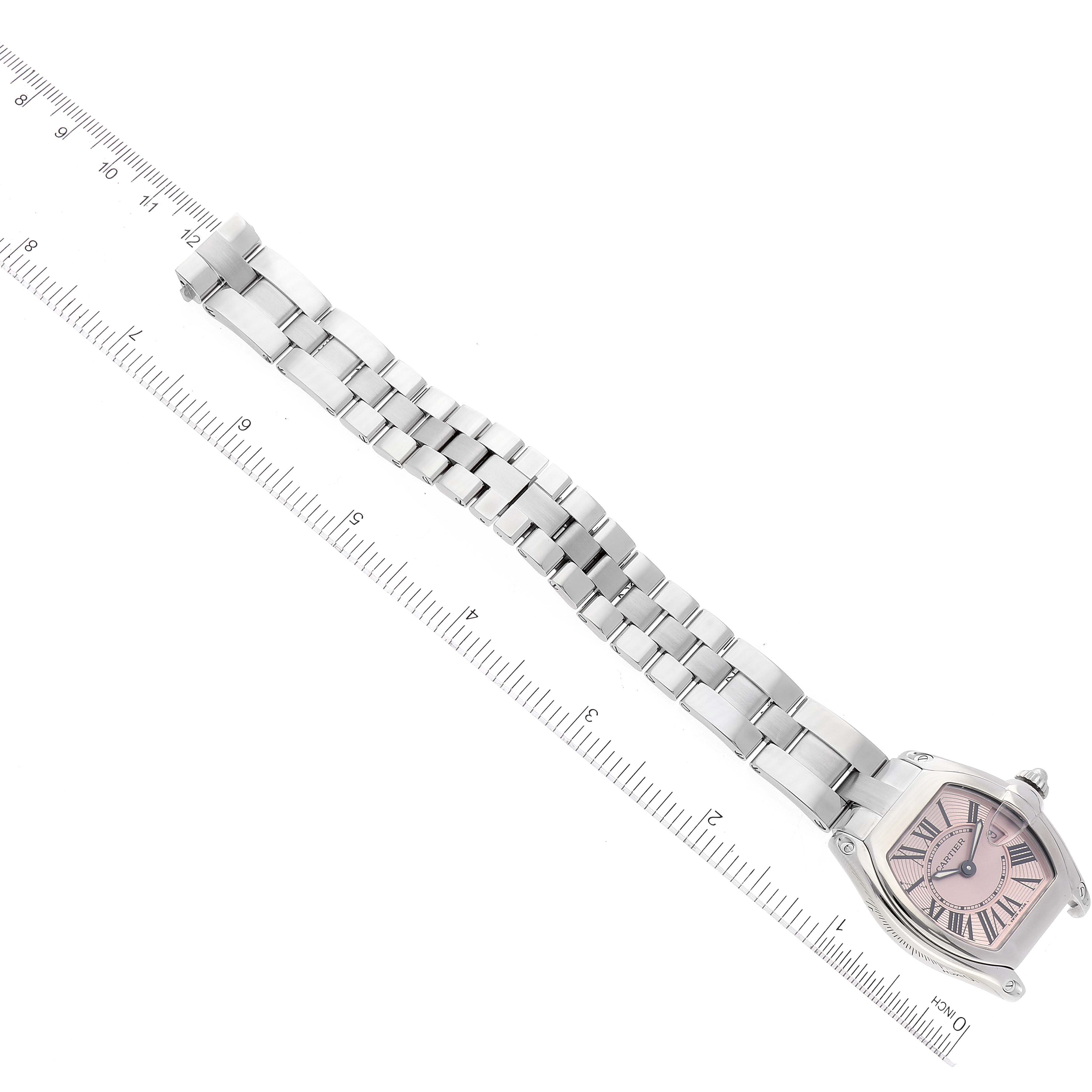 The image shows the Cartier Roadster W62017V3 Women's Stainless Steel Pink Dial W62017V3 Women's Stainless Steel Pink Dial watch at an angle, highlighting its face and entire metal link bracelet against a ruler for scale.