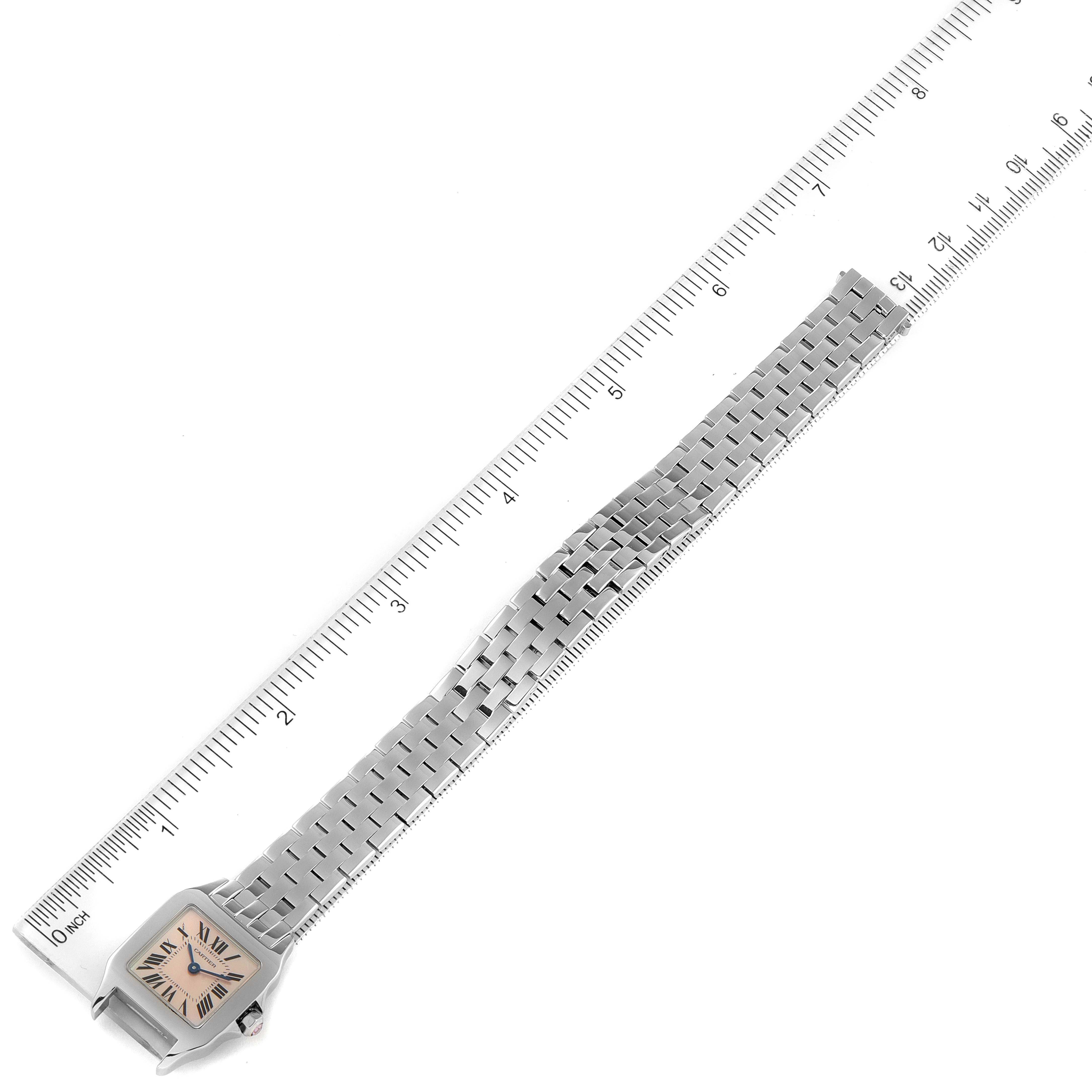 The Cartier Santos Demoiselle W25075Z5 Women's Stainless Steel Mother of Pearl Dial W25075Z5 Women's Stainless Steel Mother of Pearl Dial watch is shown lying flat with the dial and stainless steel bracelet visible next to a ruler for scale.