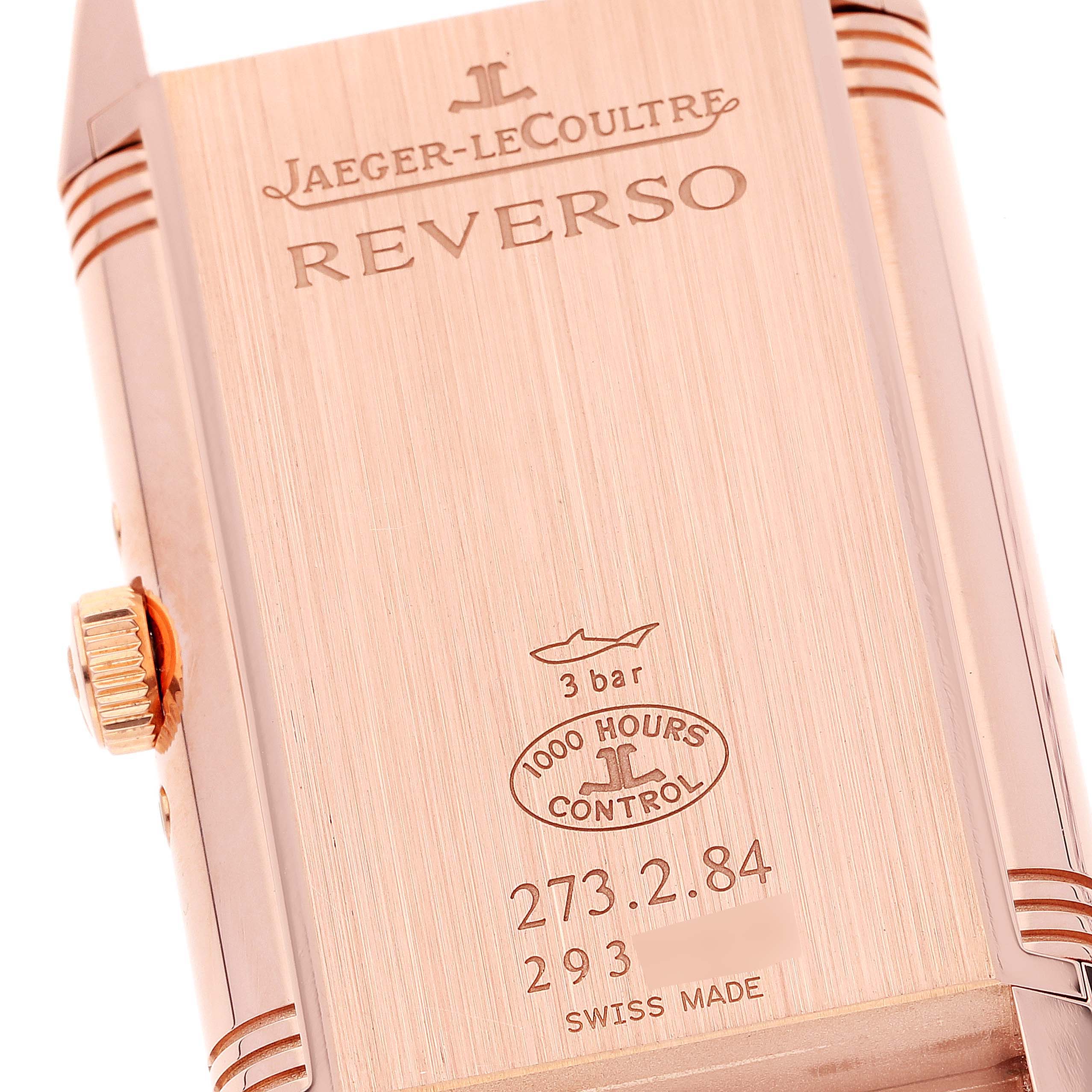 The image shows the back case of a Jaeger-LeCoultre Reverso watch, including engravings and the watch crown.