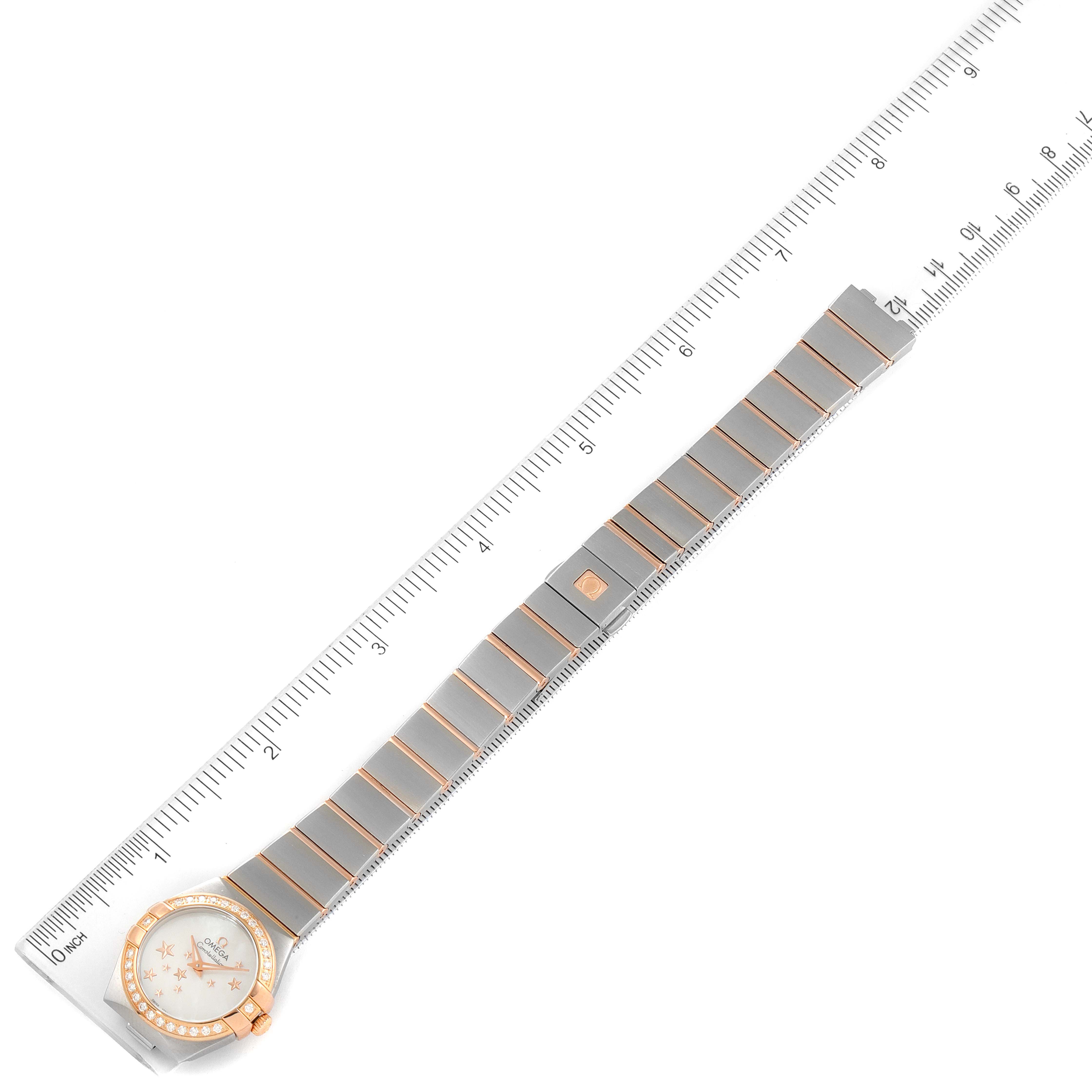 The Omega 123.25.24.60.05.002 Women's Steel and Gold (two tone) Mother of Pearl Dial 123.25.24.60.05.002 Women's Steel and Gold (two tone) Mother of Pearl Dial Constellation Star Steel Rose Gold Diamond Ladies Watch 123.25.24.60.05.002 is shown flat with a ruler beside it.