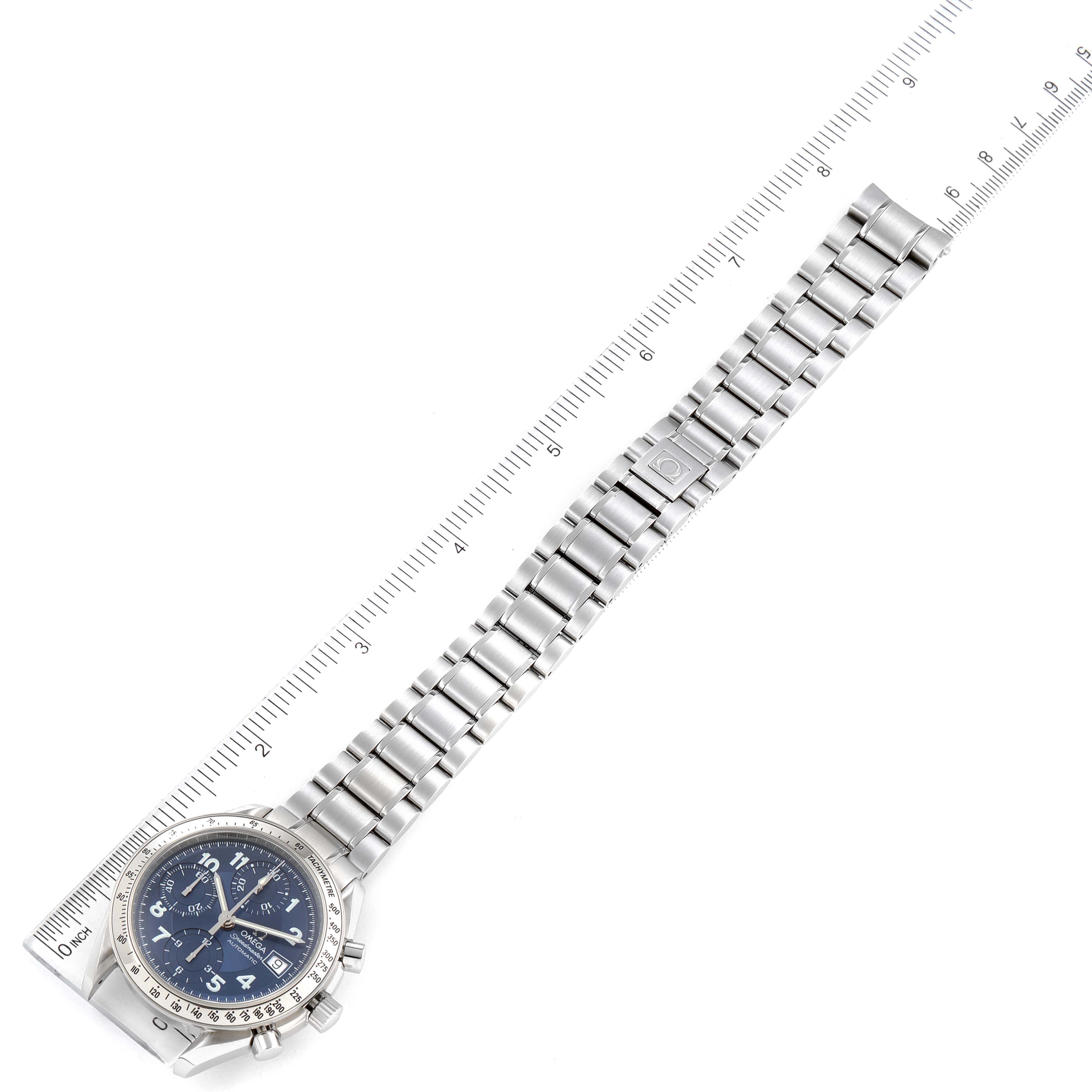 The image shows an Omega Speedmaster 3513.82.00 Men's Stainless Steel Blue Dial 3513.82.00 Men's Stainless Steel Blue Dial watch laid flat next to a ruler, highlighting the dial, case, and full bracelet.