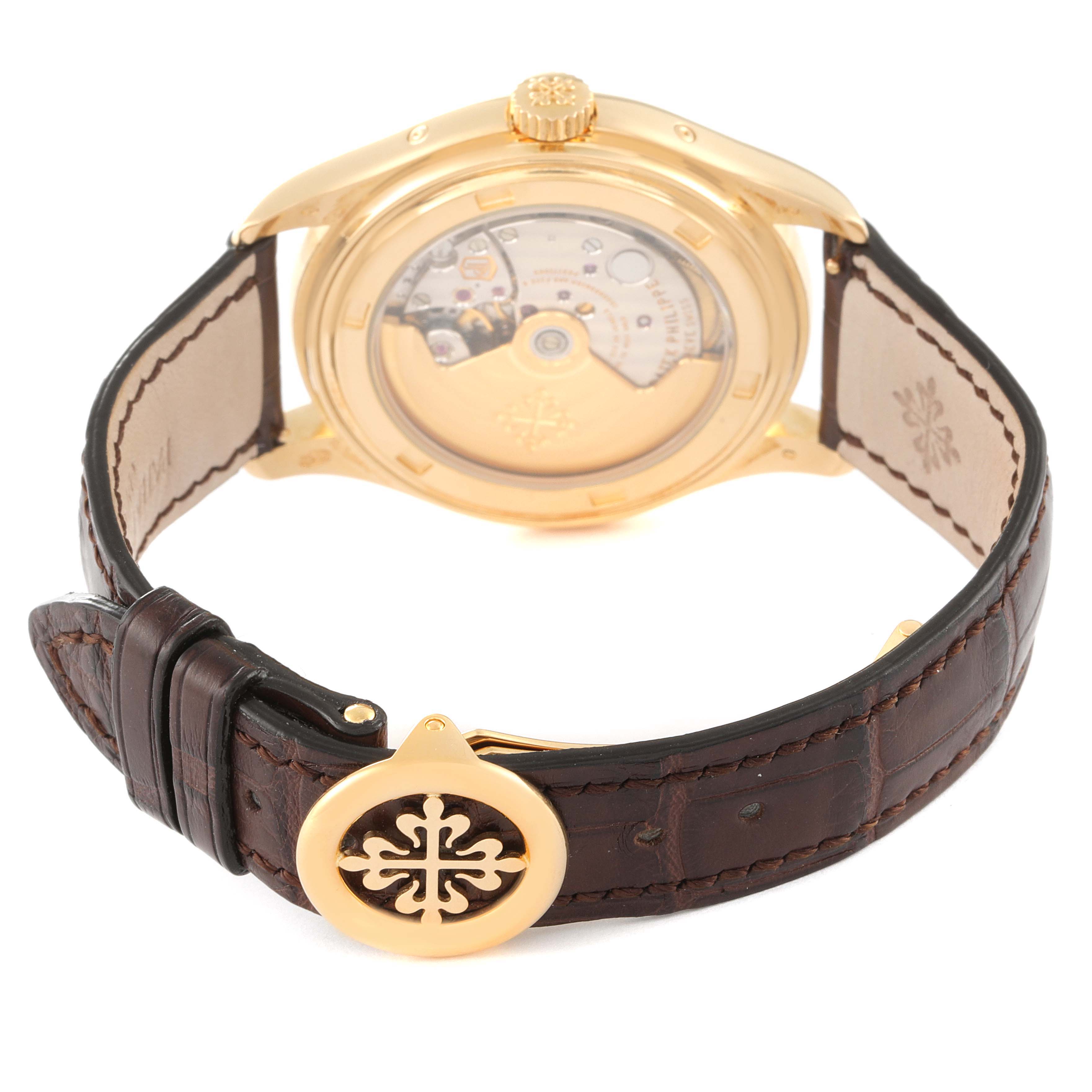 The image shows the back view of a Patek Philippe Complications 5146J Men's Yellow Gold Beige Dial 5146J Men's Yellow Gold Beige Dial watch, highlighting the movement, crown, and leather strap.