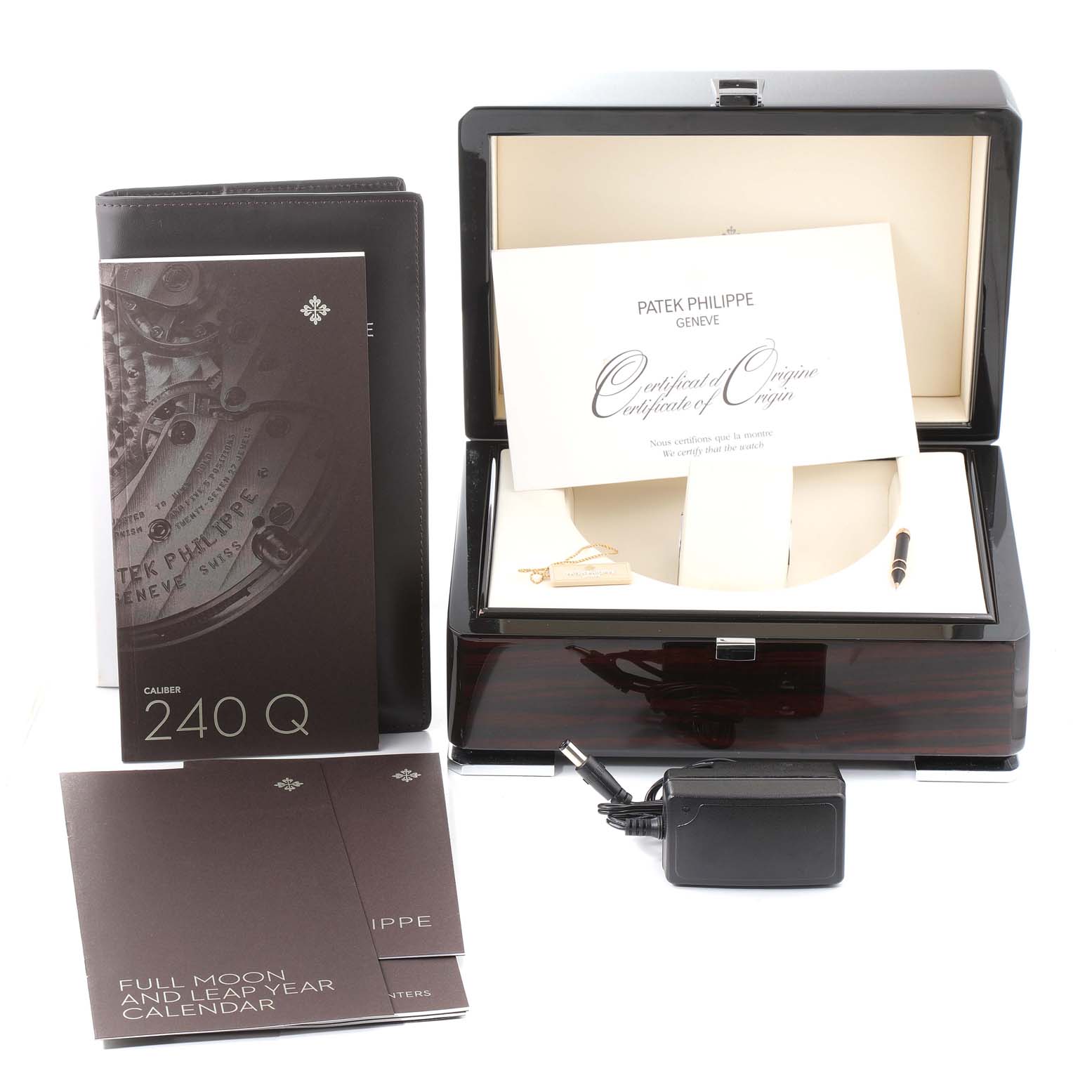 The image shows a Patek Philippe Complications 5140R-001 Men's Rose Gold Brown Dial 5140R-001 Men's Rose Gold Brown Dial model's presentation box with accompanying documents and accessories from a front angle.