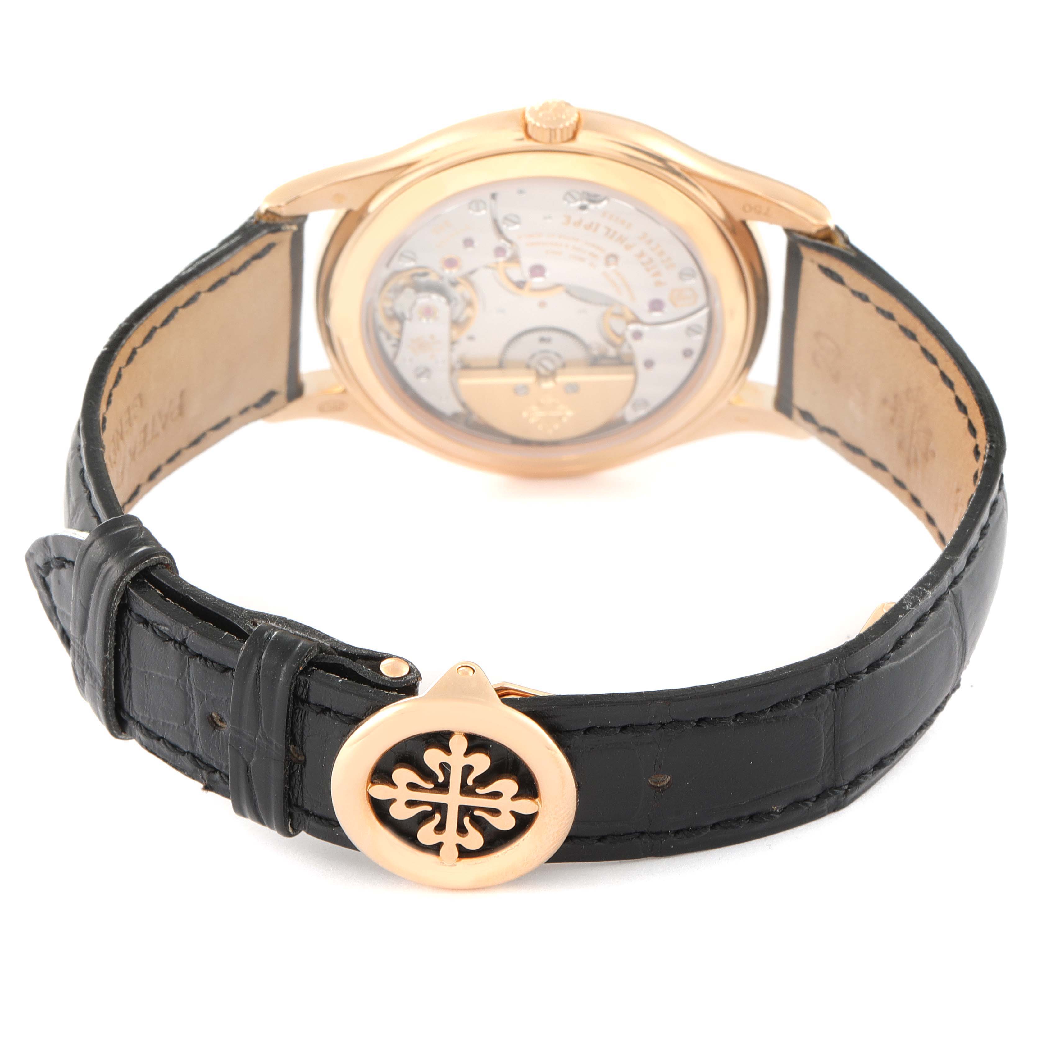 The image shows the back view of a Patek Philippe Complications 5140R-001 Men's Rose Gold Brown Dial 5140R-001 Men's Rose Gold Brown Dial watch, highlighting its movement and leather strap with a branded clasp.