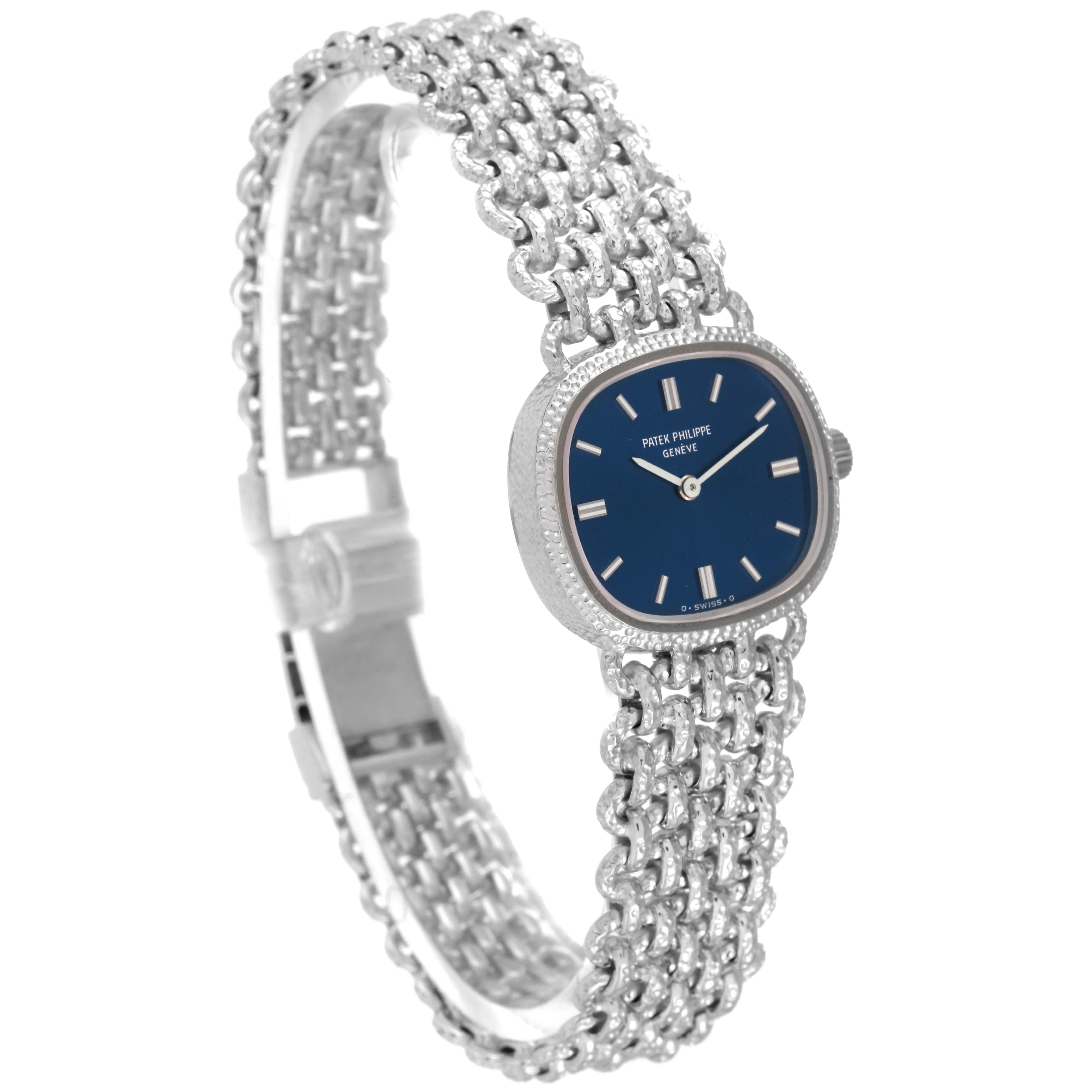 The image shows a side angle of the Patek Philippe Golden Ellipse 4133 Women's White Gold Blue Dial 4133 Women's White Gold Blue Dial watch, highlighting its intricate bracelet and blue dial.