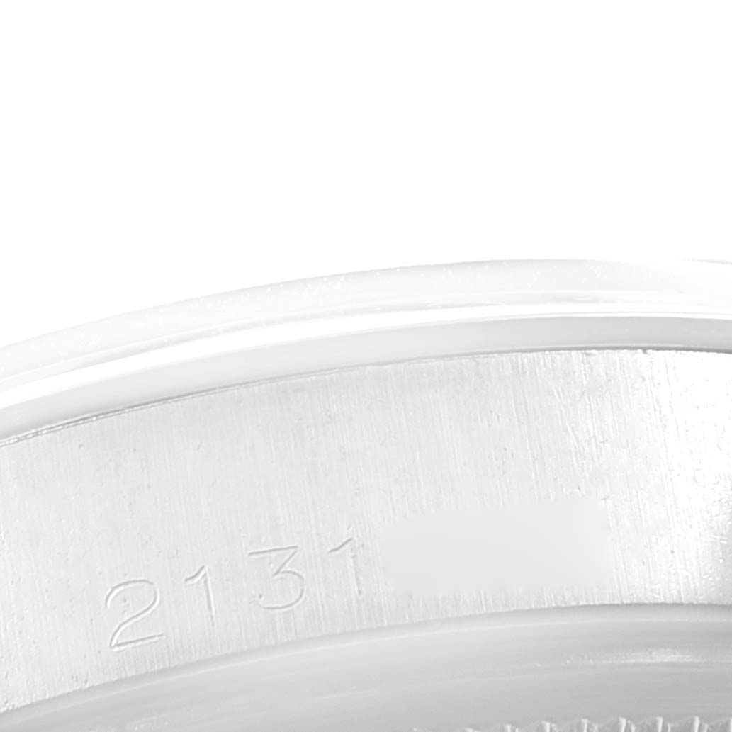 This close-up image shows the edge of the bezel and caseback of a Rolex Vintage Collection 1500 Men
s Stainless Steel Silver Dial 1500 Men
s Stainless Steel Silver Dial model with serial number 2131 engraved.