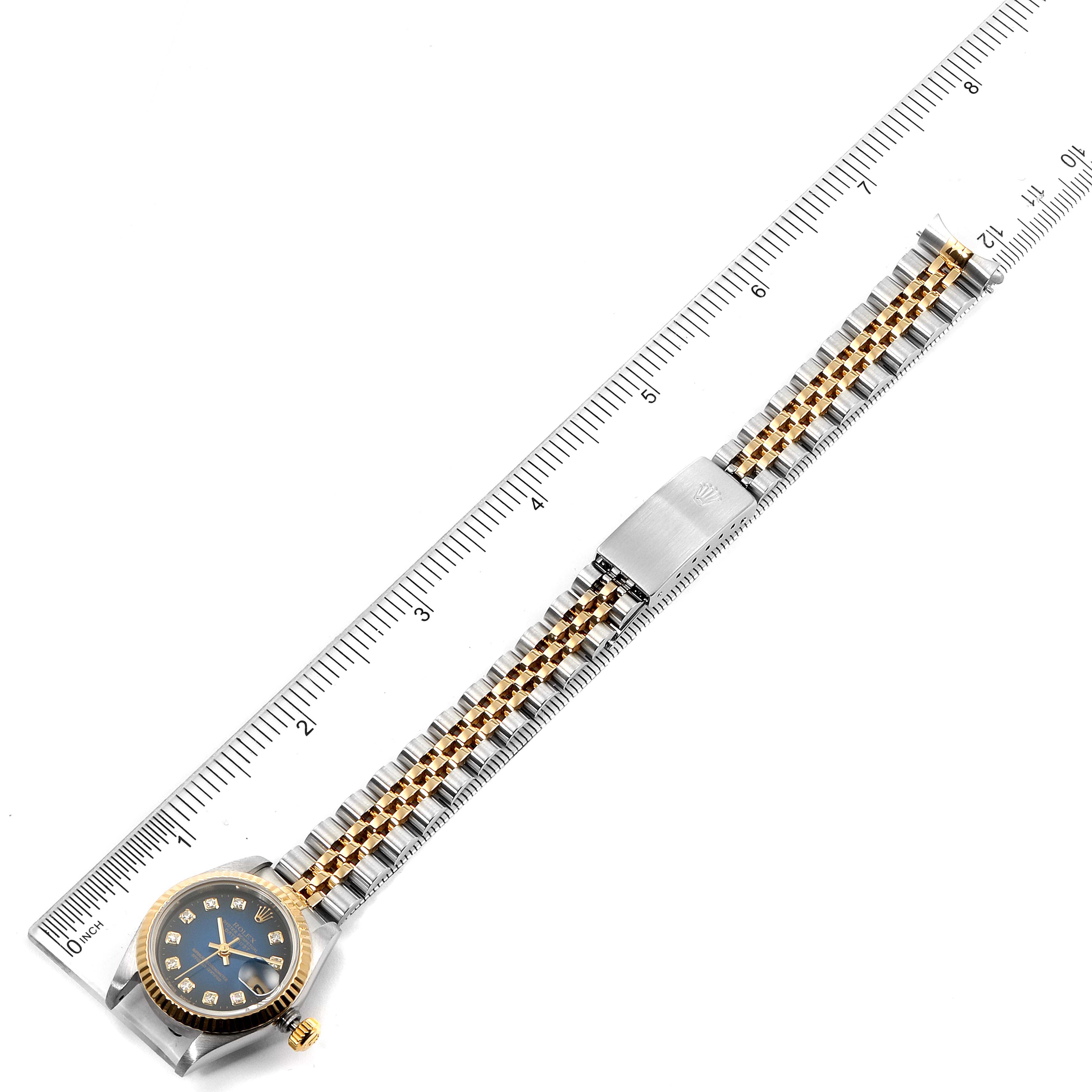 This image shows a top view of a Rolex Datejust 69173 Women
s Steel and Gold (two tone) Blue Dial 69173 Women
s Steel and Gold (two tone) Blue Dial watch, including its full bracelet alongside a measuring ruler.