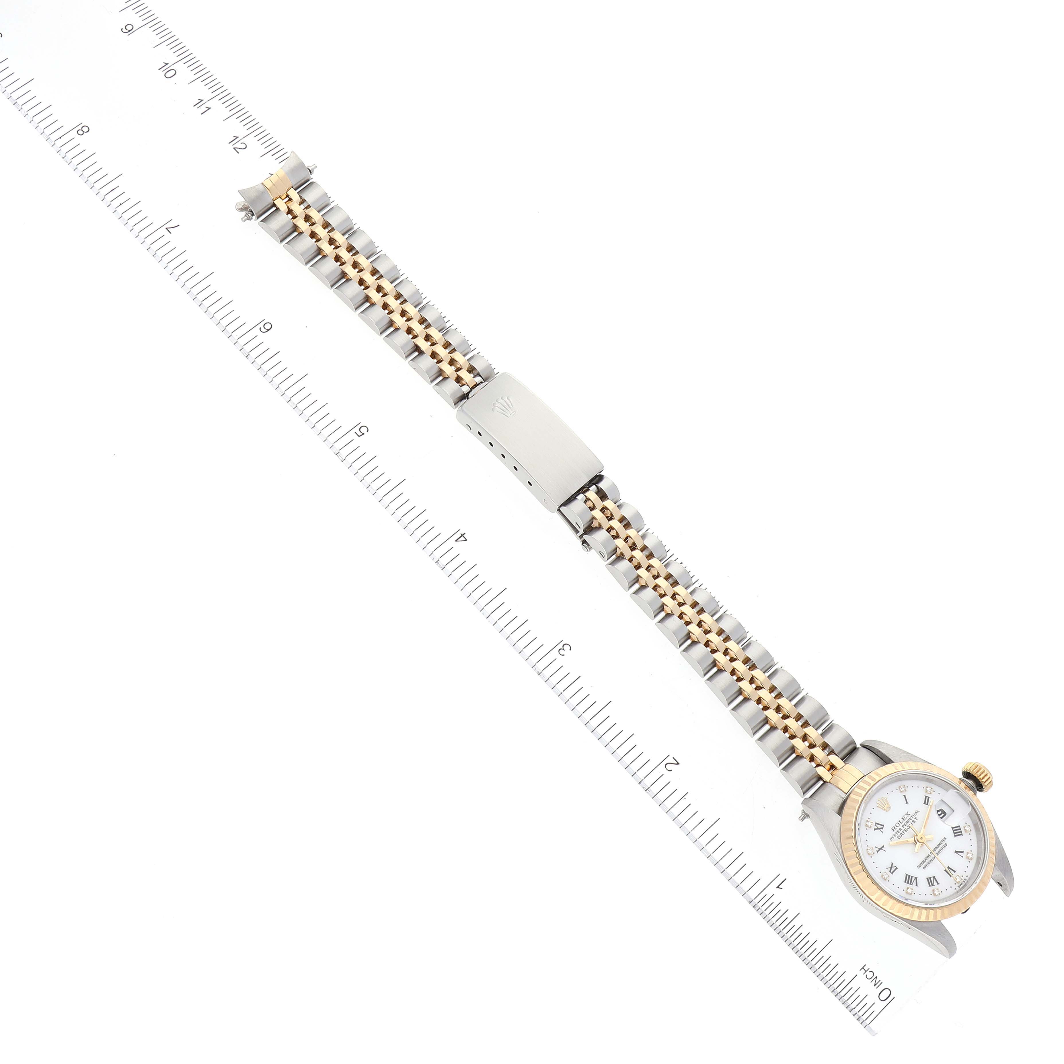 The image shows a top-down angle of a Rolex Datejust 69173 Women's Steel and Gold (two tone) White Dial 69173 Women's Steel and Gold (two tone) White Dial watch displaying its bracelet, clasp, and partial watch face along a ruler for scale.
