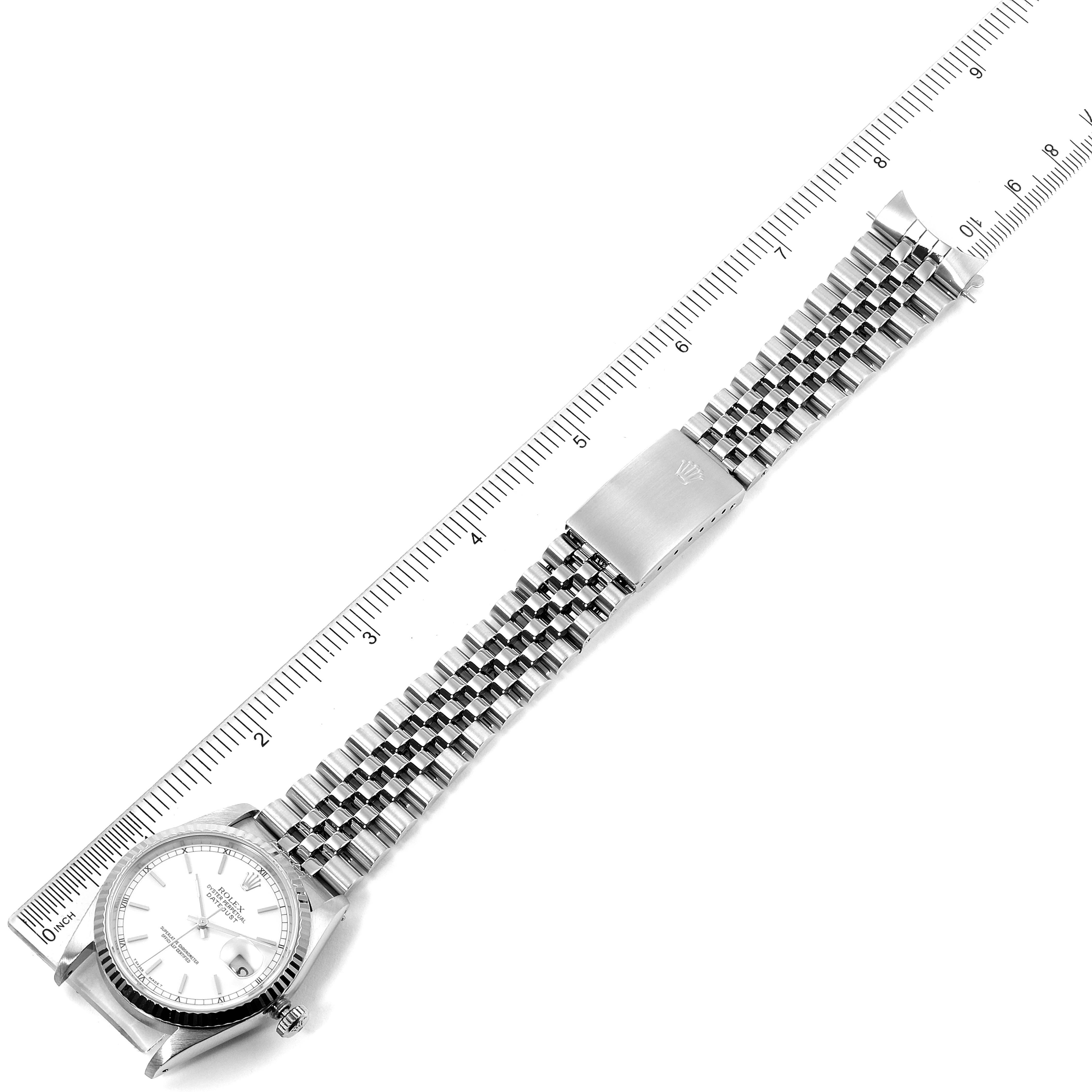 The image shows a top view of a Rolex Datejust 16234 Men
s Stainless Steel White Dial 16234 Men
s Stainless Steel White Dial watch with a Jubilee bracelet laid next to a ruler.
