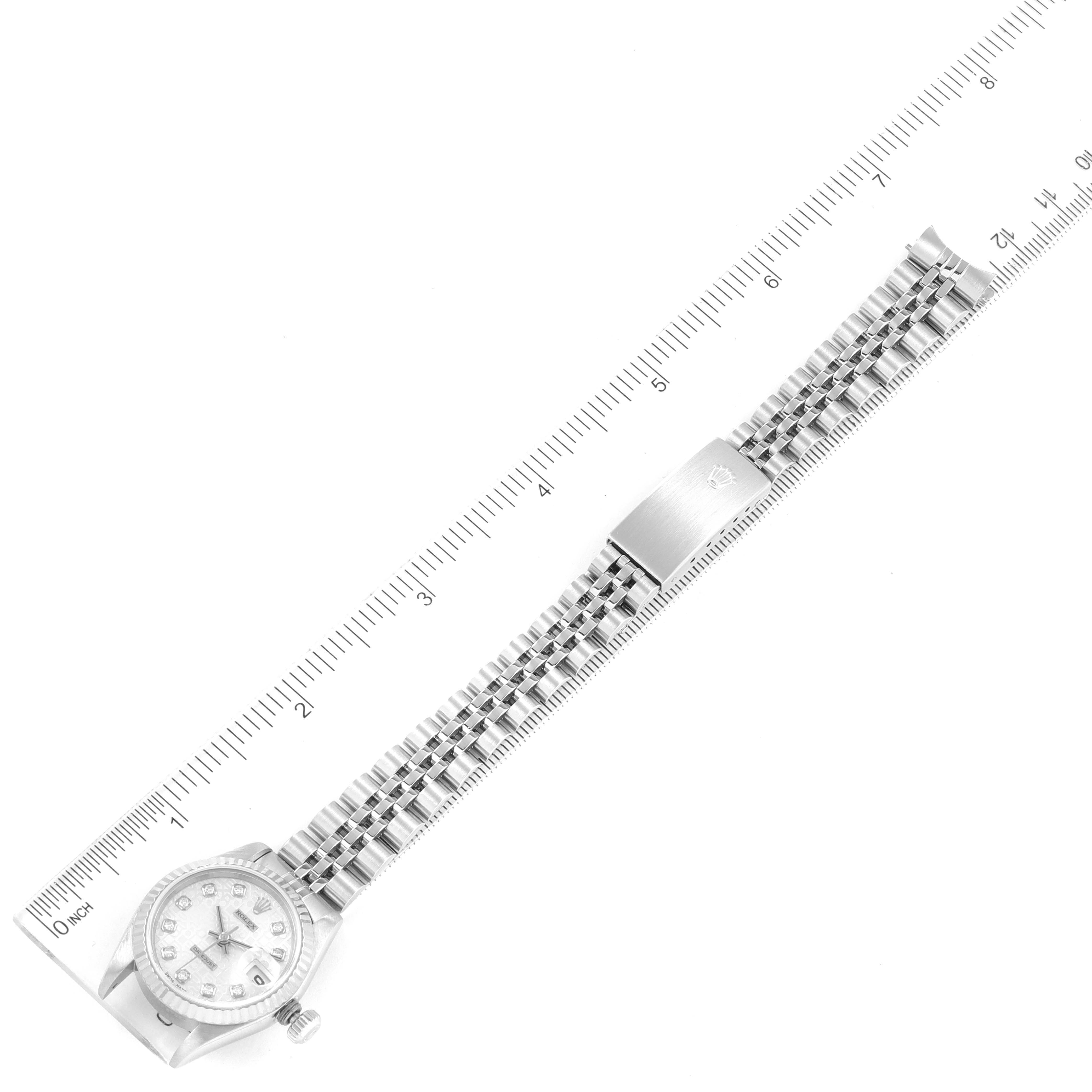 The Rolex Datejust 69174 Women
s Stainless Steel Silver Dial 69174 Women
s Stainless Steel Silver Dial watch is shown laid flat with its face and full metal bracelet visible, next to a ruler for scale.