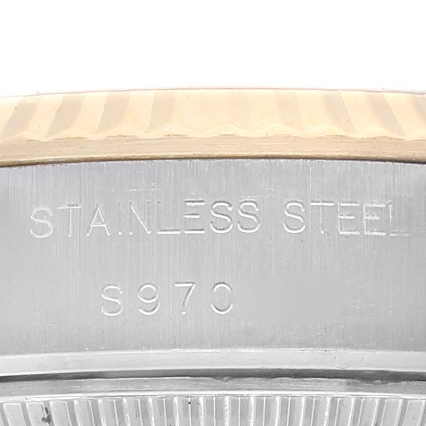 This close-up image shows the side of the stainless steel casing of the Rolex Datejust 69173 Women's Steel and Gold (two tone) Champagne Dial 69173 Women's Steel and Gold (two tone) Champagne Dial watch with an engraving of the material and a serial number.