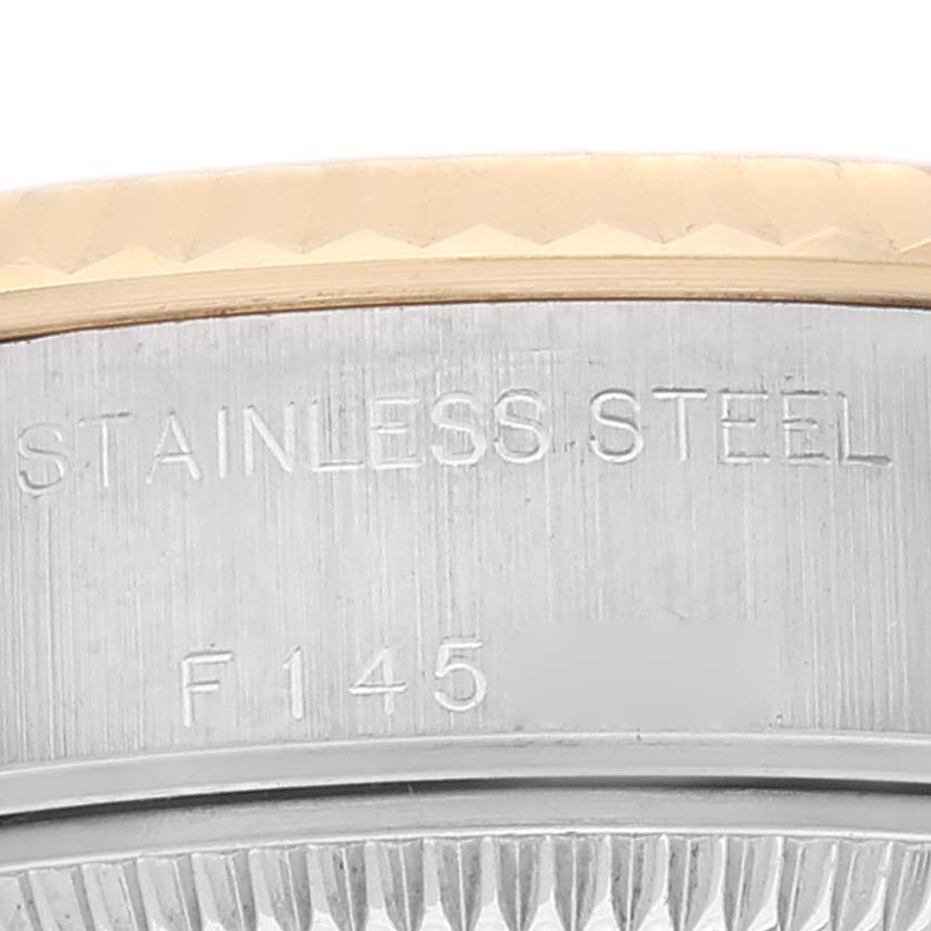 This close-up image of a Rolex Datejust 79173 Women's Steel and Gold (two tone) Grey Dial 79173 Women's Steel and Gold (two tone) Grey Dial watch shows the stainless steel bezel and engravings.