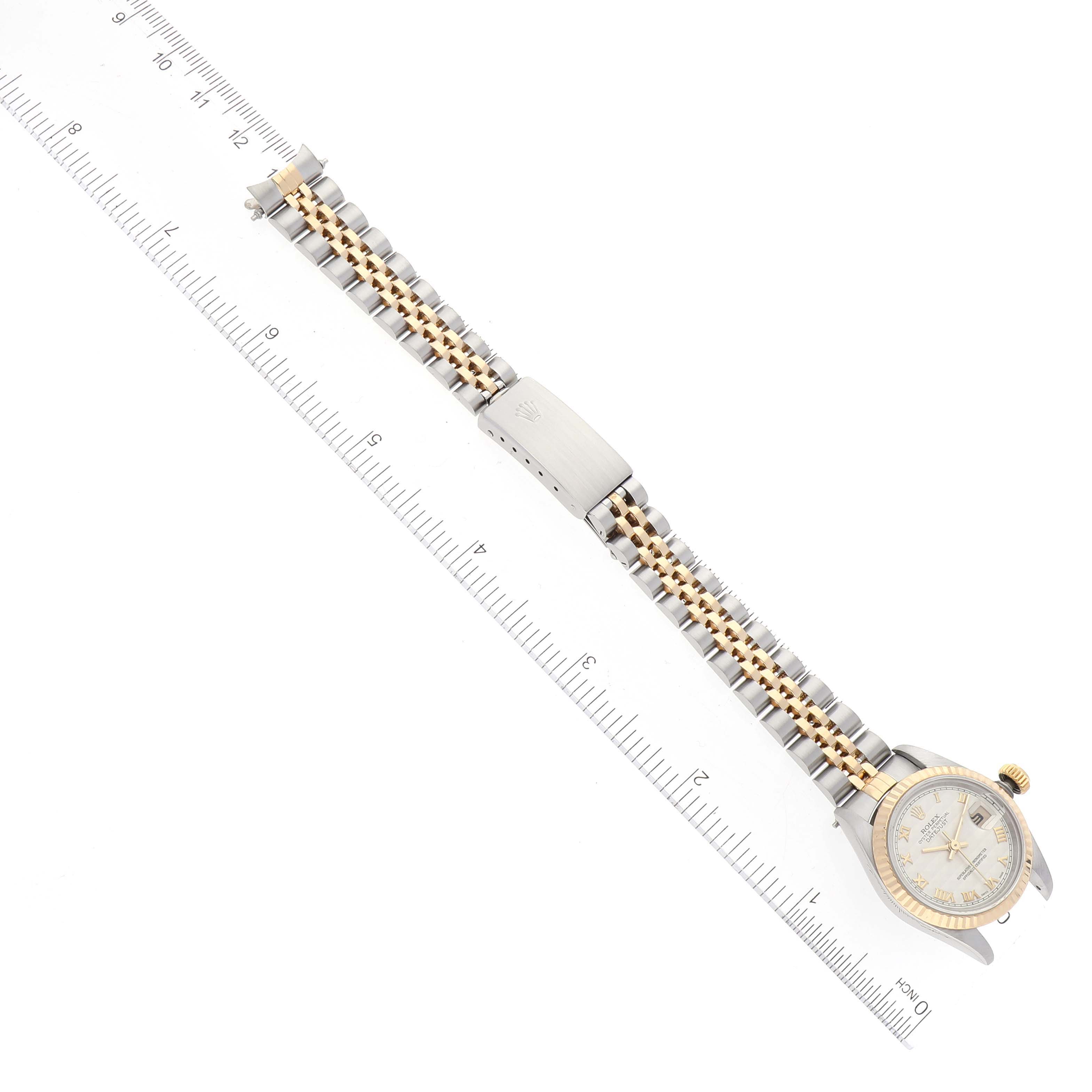 The image shows a top-down view of a Rolex Datejust 69173 Women's Steel and Gold (two tone) Beige Dial 69173 Women's Steel and Gold (two tone) Beige Dial watch with its full bracelet and clasp alongside a ruler for scale.