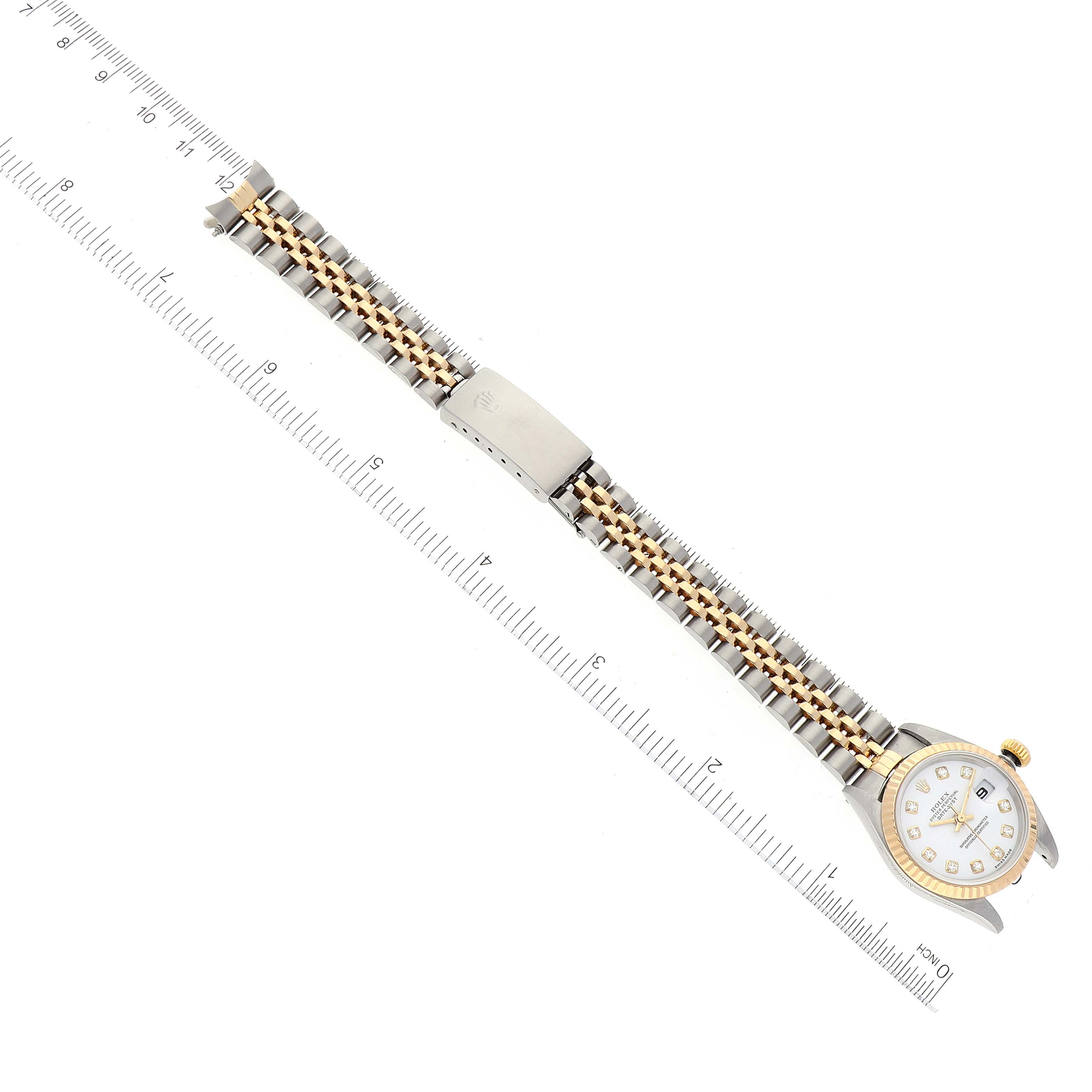 The image shows a Rolex Datejust 79173 Women's Steel and Gold (two tone) White Dial 79173 Women's Steel and Gold (two tone) White Dial watch laid flat with its bracelet extended, alongside a measuring ruler for scale.
